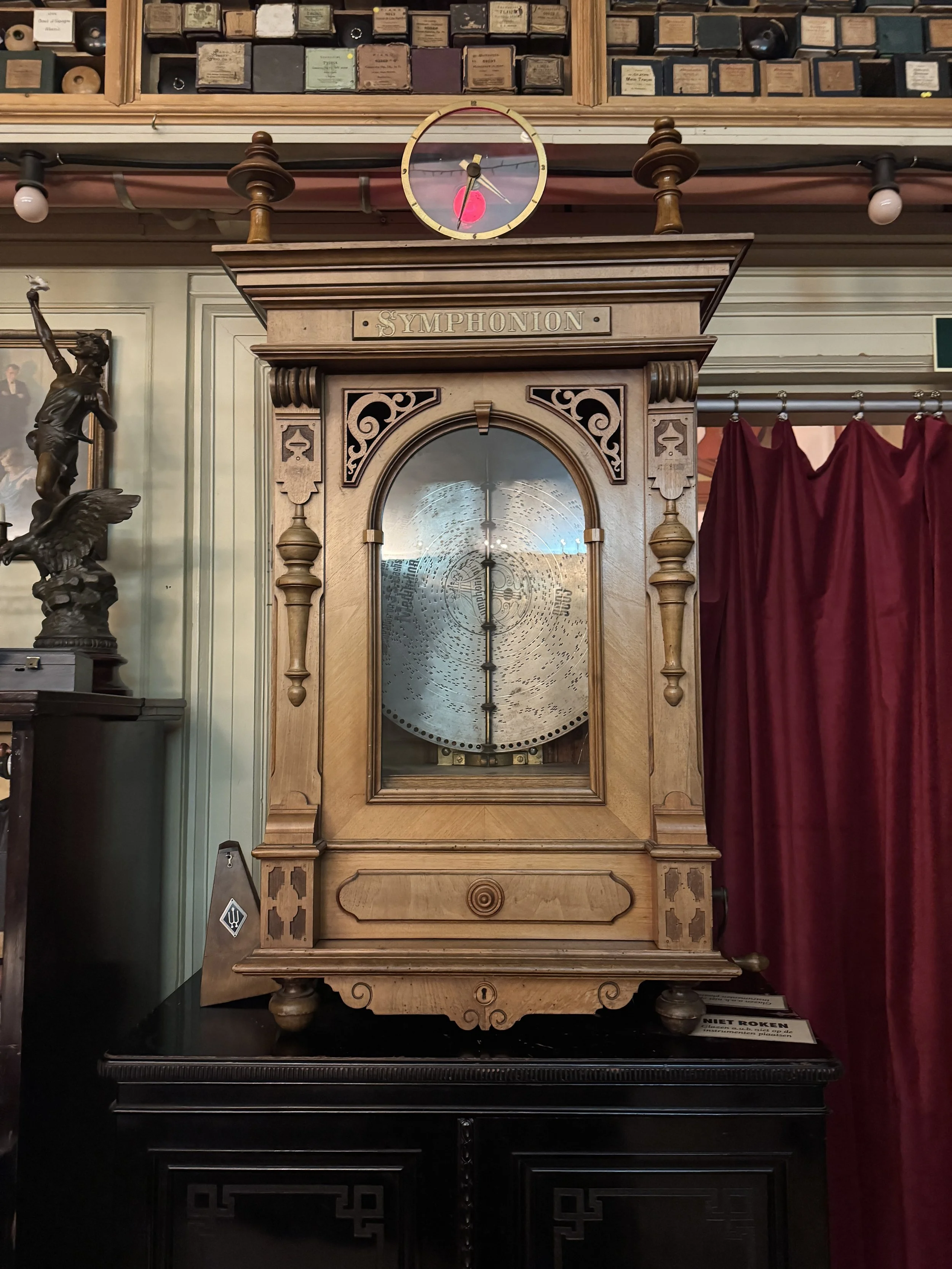 Antique self-playing pianola cabinet with ornate wood detailing at Geelvinck Pianola Museum Amsterdam