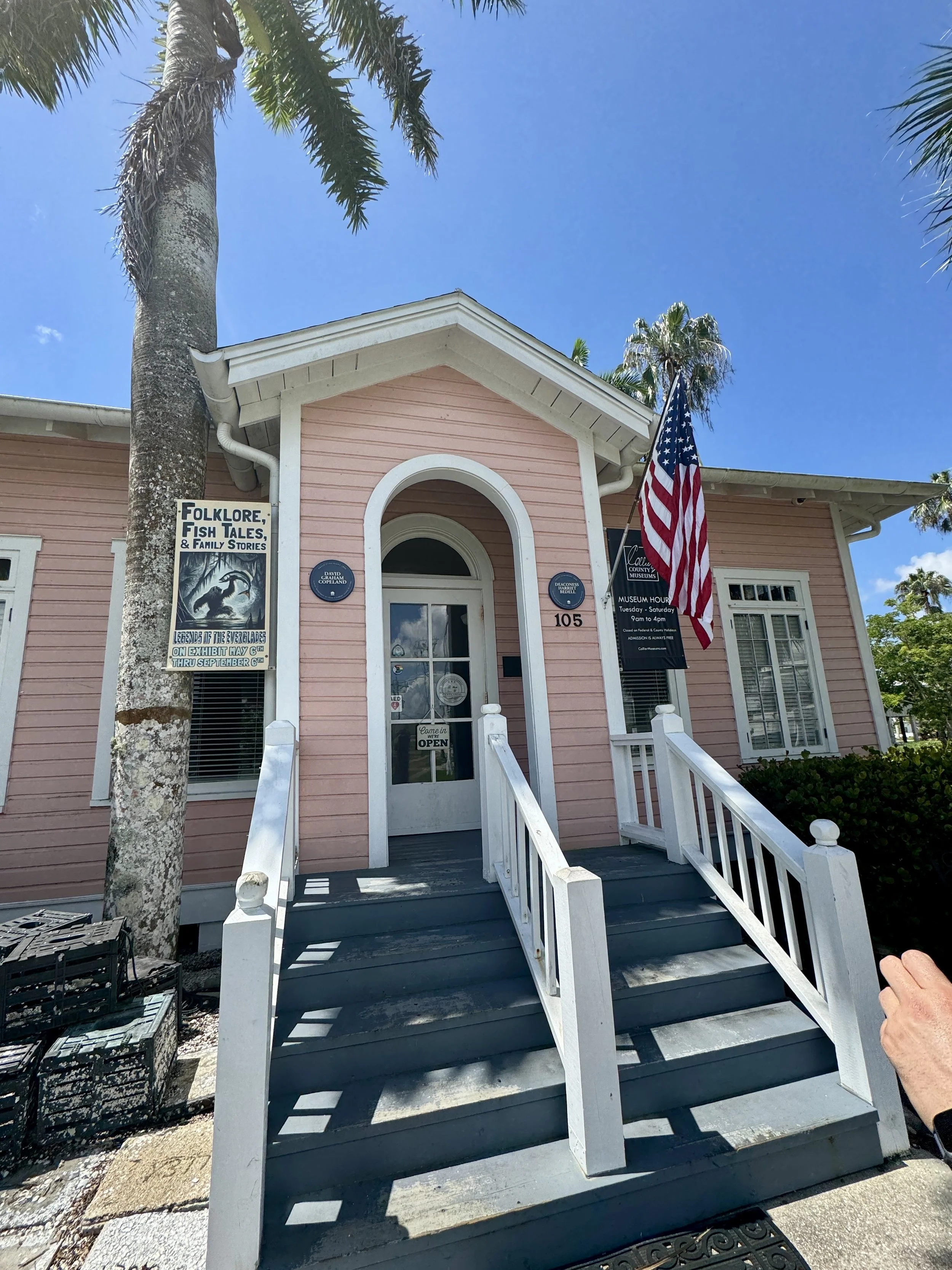 exterior of the everglades museum historic building in Everglades City Florida with front steps and american flag
