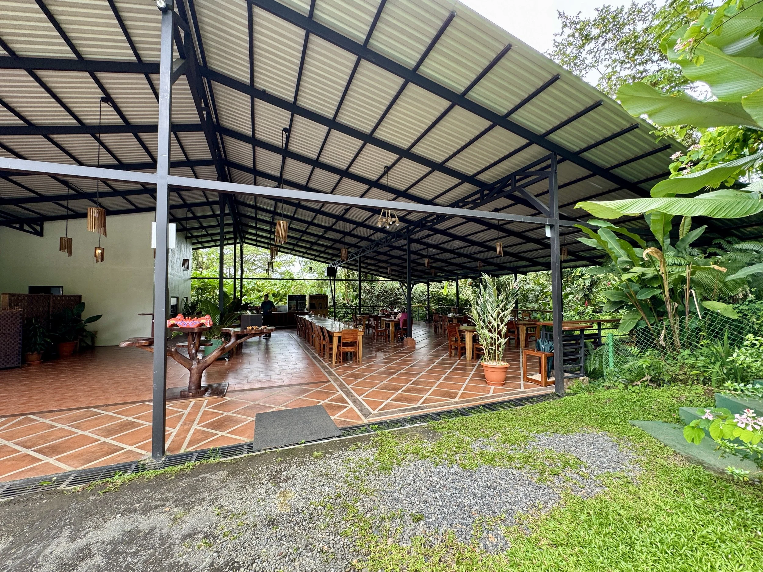 Open-air restaurant with covered seating and garden views at La Finquita farm