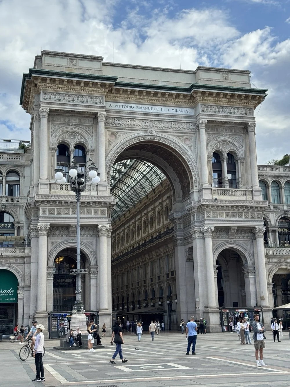 Ornate entrance arch of Galleria Vittorio Emanuele II beside Milan Cathedral