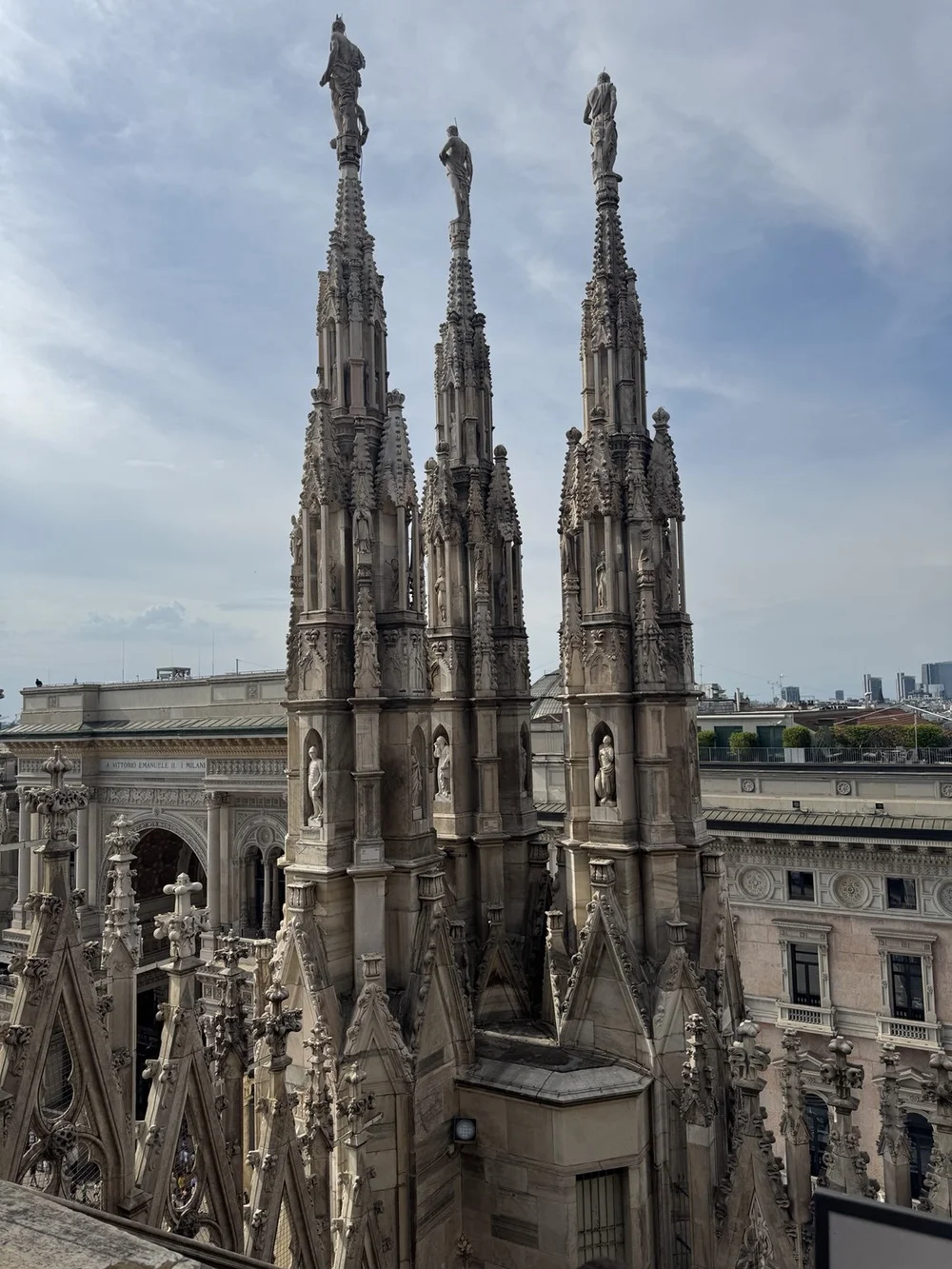 Three Gothic spires on Milan Cathedral overlooking the Galleria Vittorio Emanuele II.