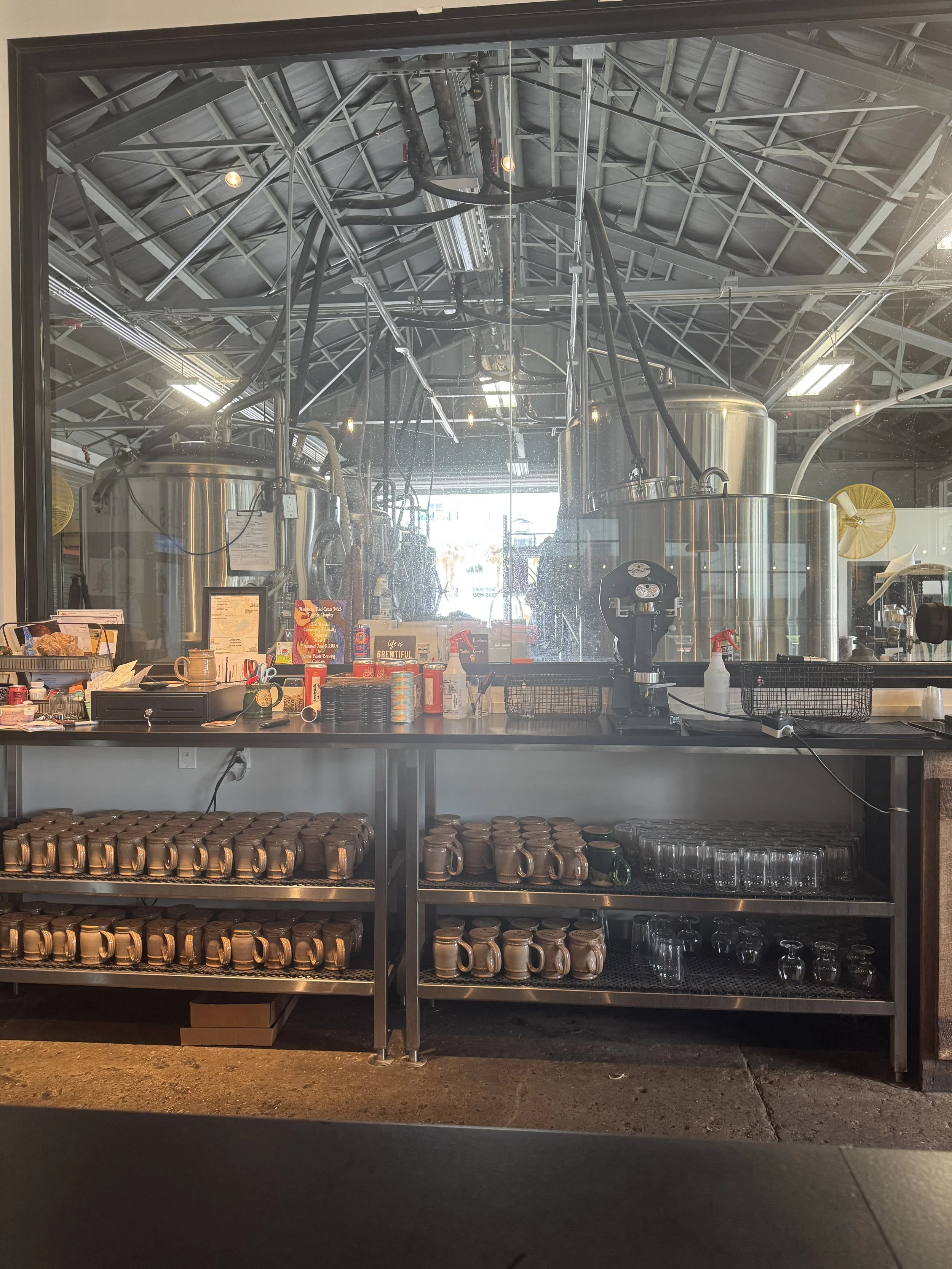 View of the brewing tanks through the glass wall inside Grove Roots Brewing Company in Winter Haven.
