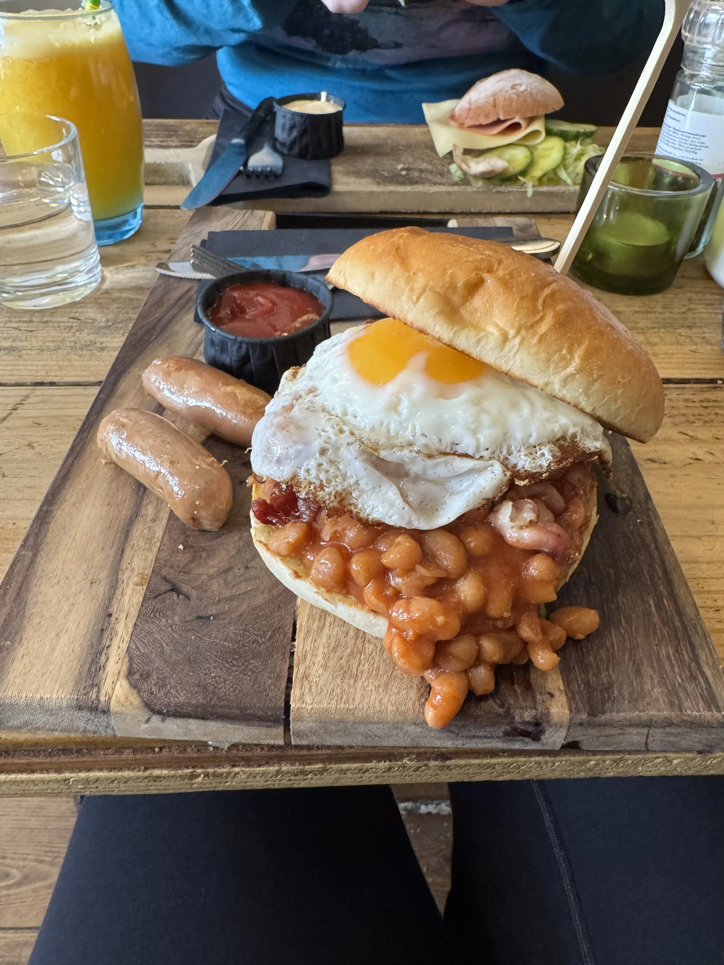 Breakfast sandwich with beans, fried egg, and sausage served at Coffee & Bites in Amsterdam