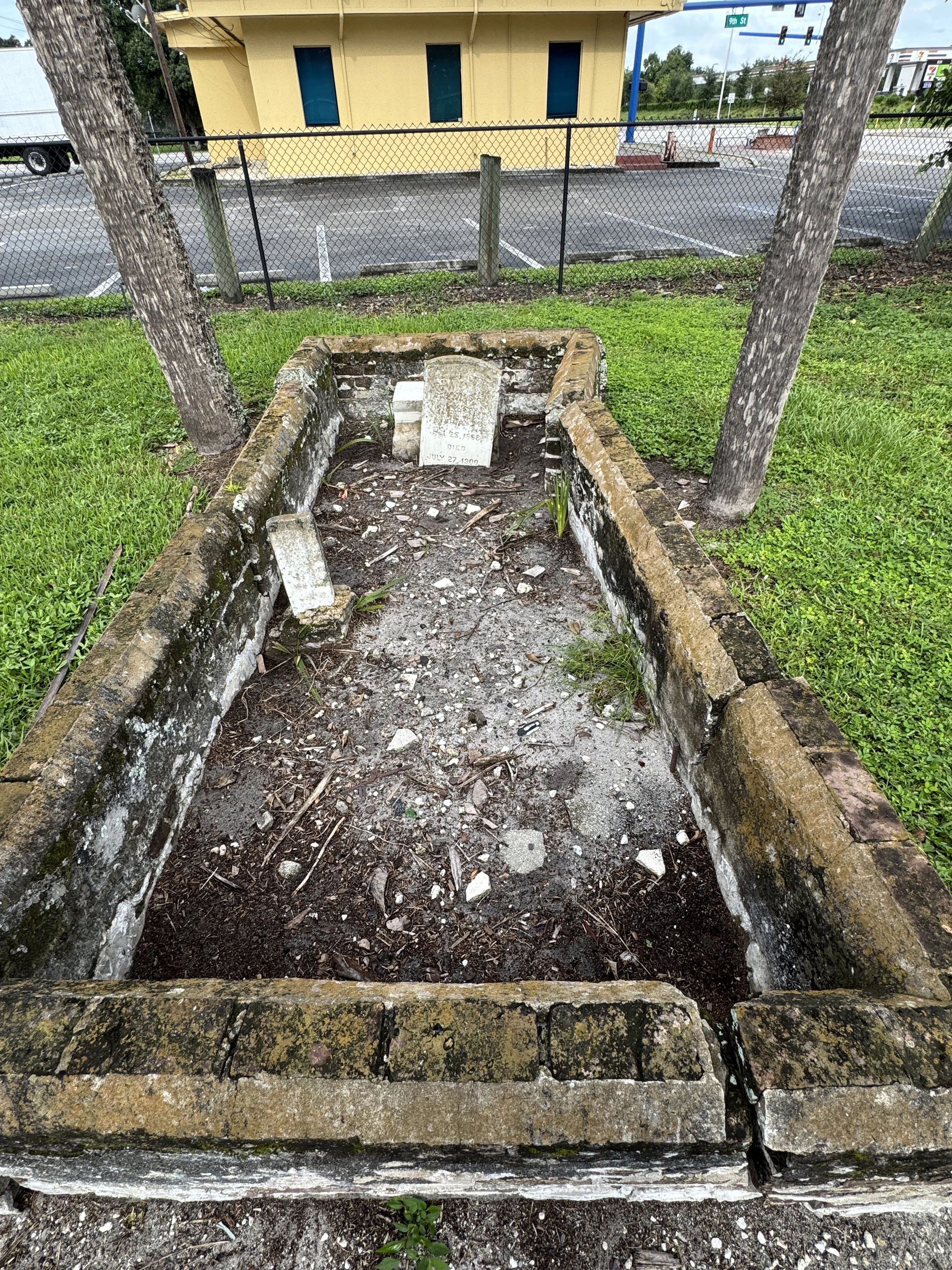 Historic gravesite from a forgotten church located in a grassy parking lot median in Immokalee, Florida.