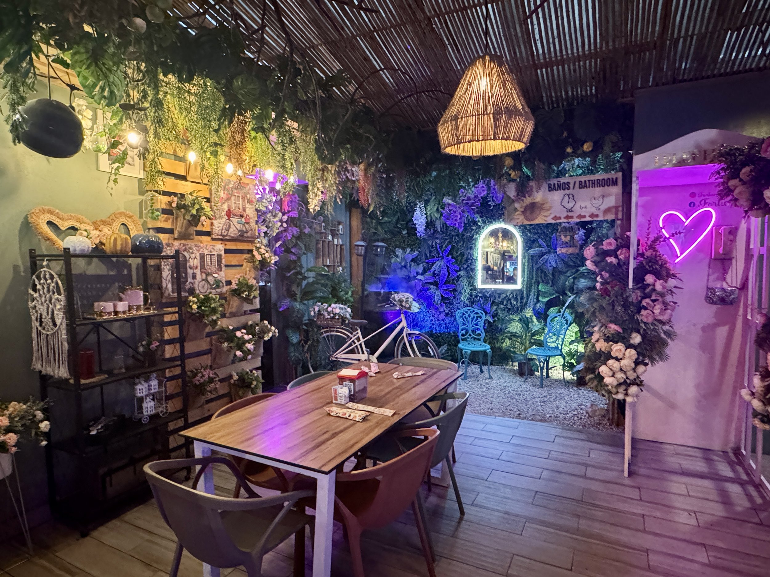 Cozy restaurant interior with colorful wall art, warm lighting, hanging décor, and wooden tables at Restaurante Fortuñeño.