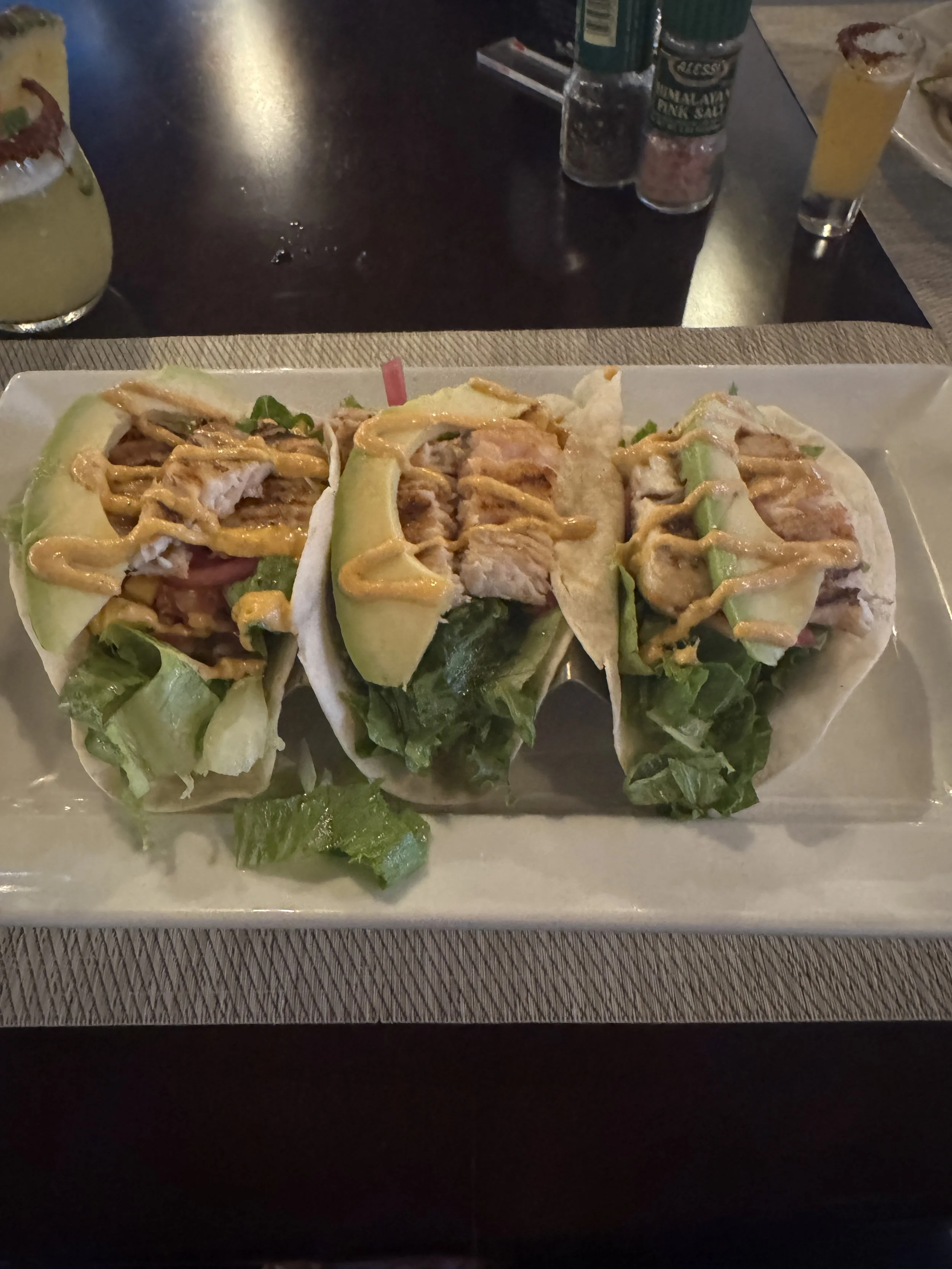 Plate of Maui mahi tacos topped with fresh greens, served at Manglar Bar and Restaurant in Jacó.
