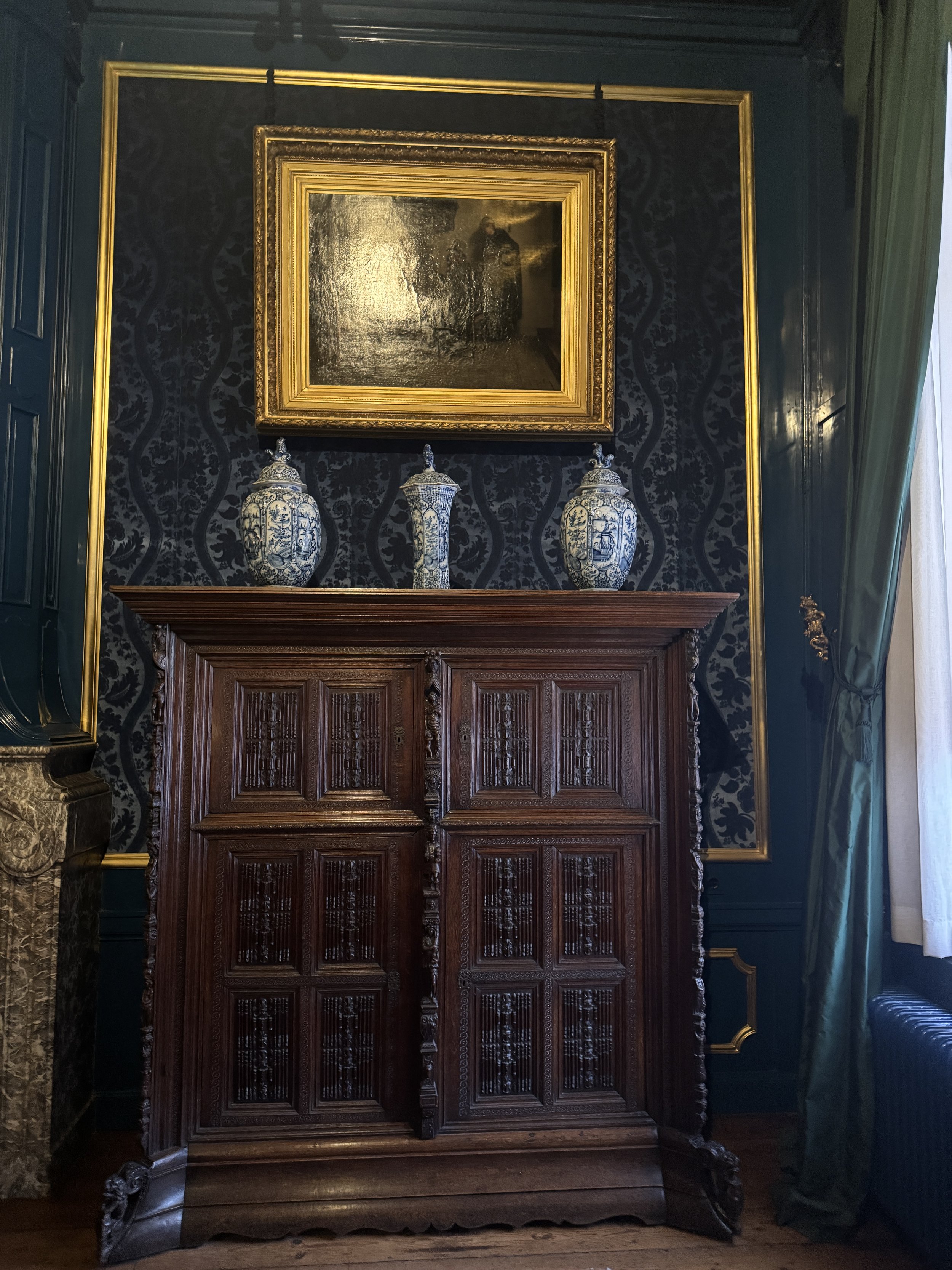 Historic interior room with antique cabinet and framed painting at Huis Willet-Holthuysen in Amsterdam