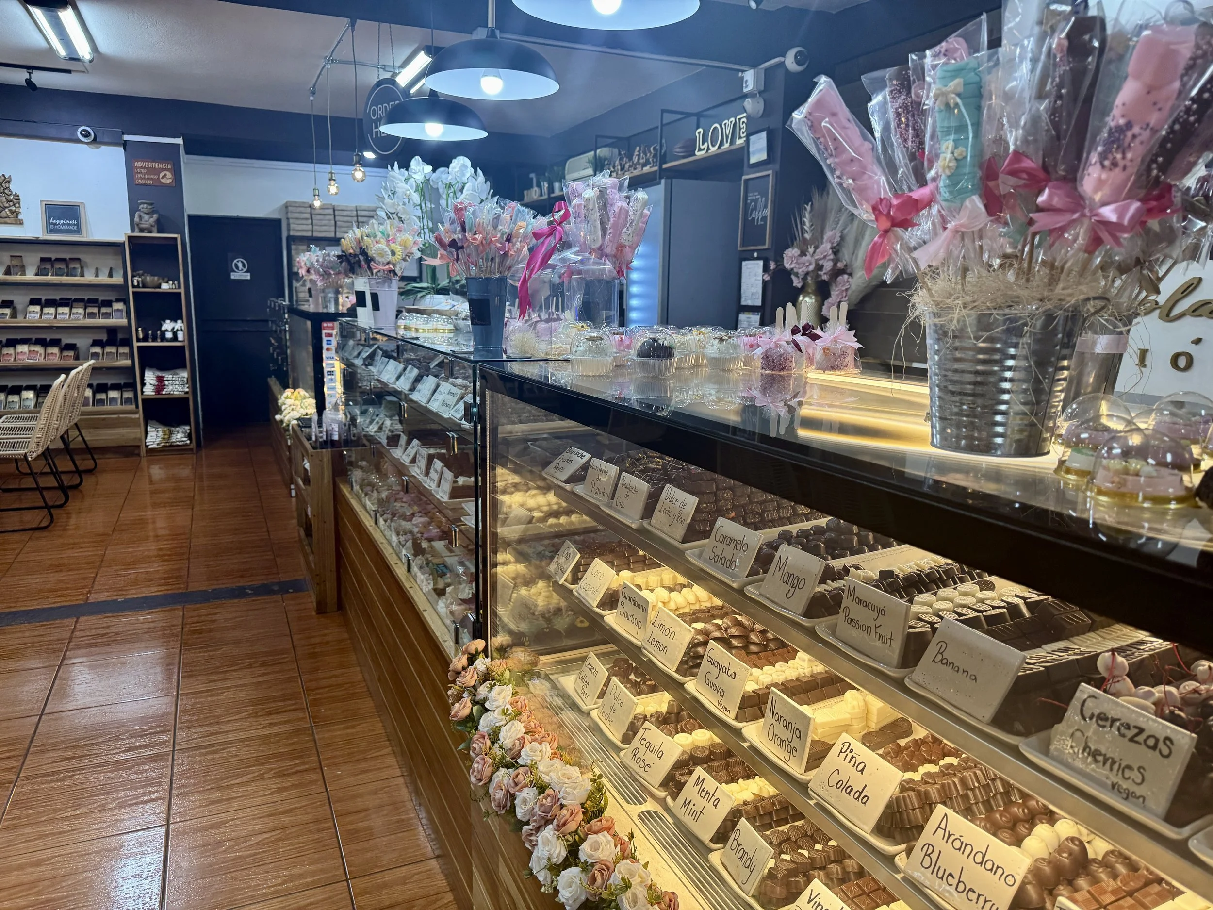 Interior view of a chocolate shop with display counters and rows of assorted chocolates and confections.