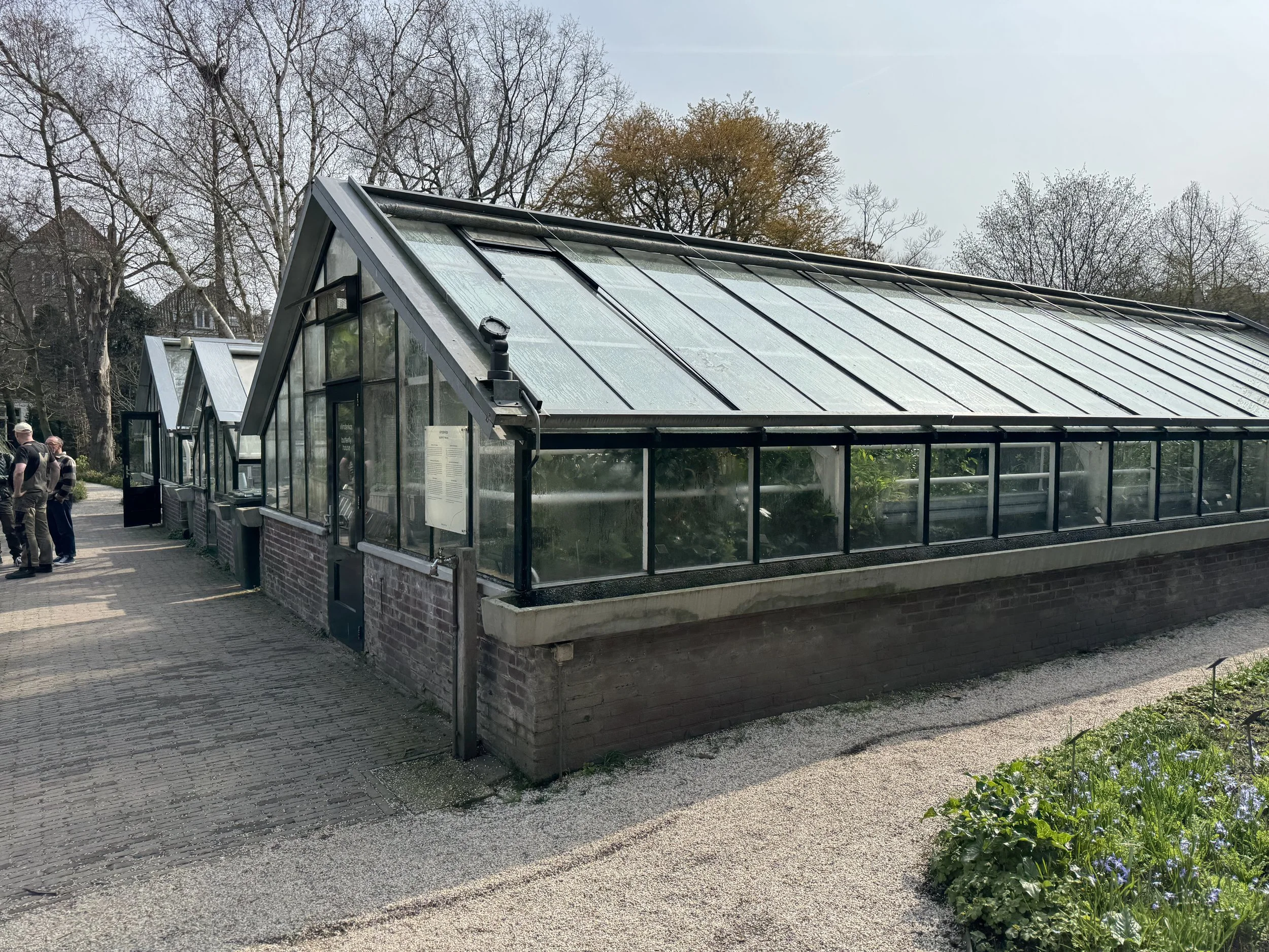 Exterior greenhouse building at Hortus Botanicus in Amsterdam with glass structure and garden path