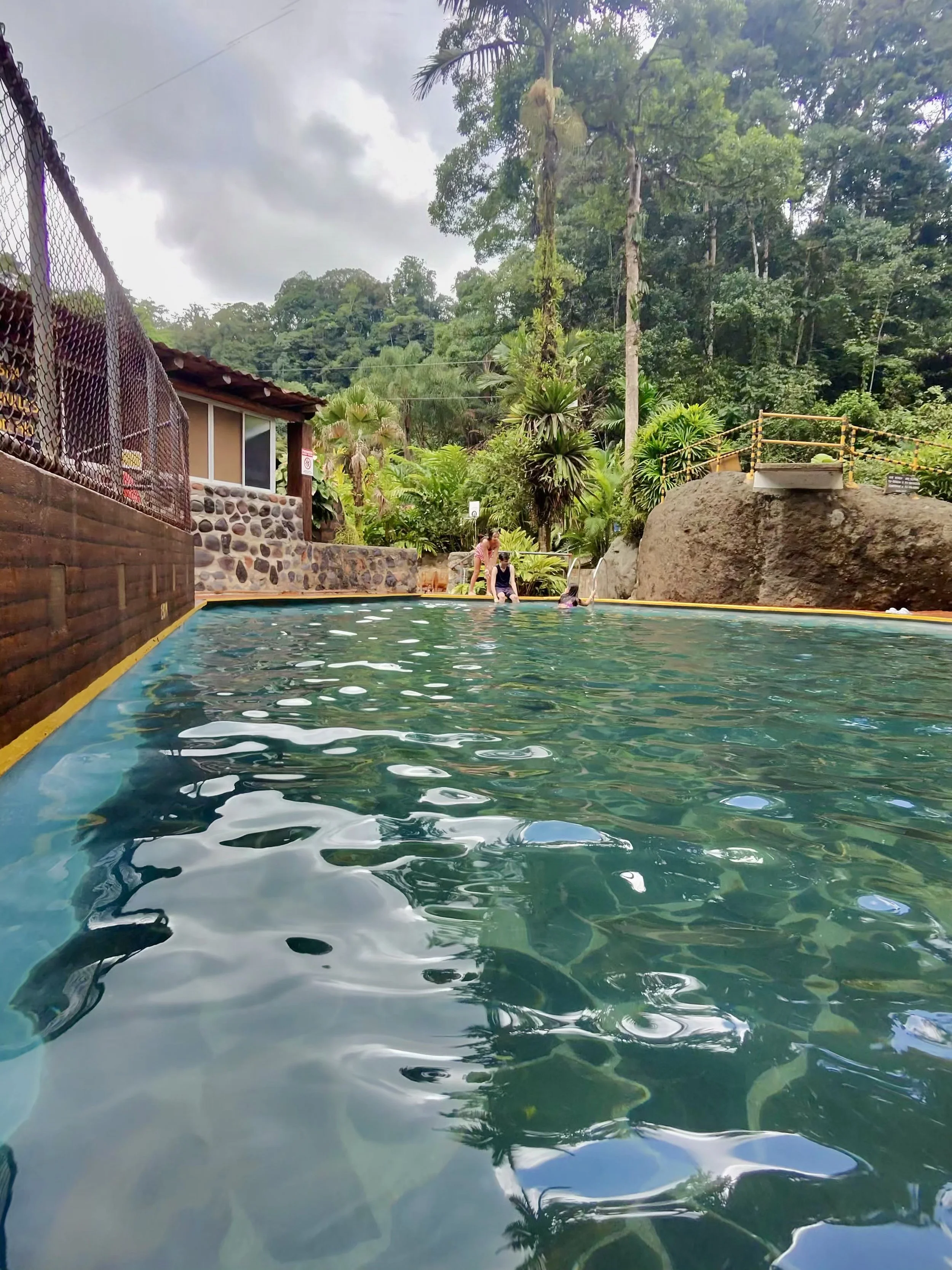 Mineral thermal pool surrounded by lush forest at Recreo Verde.