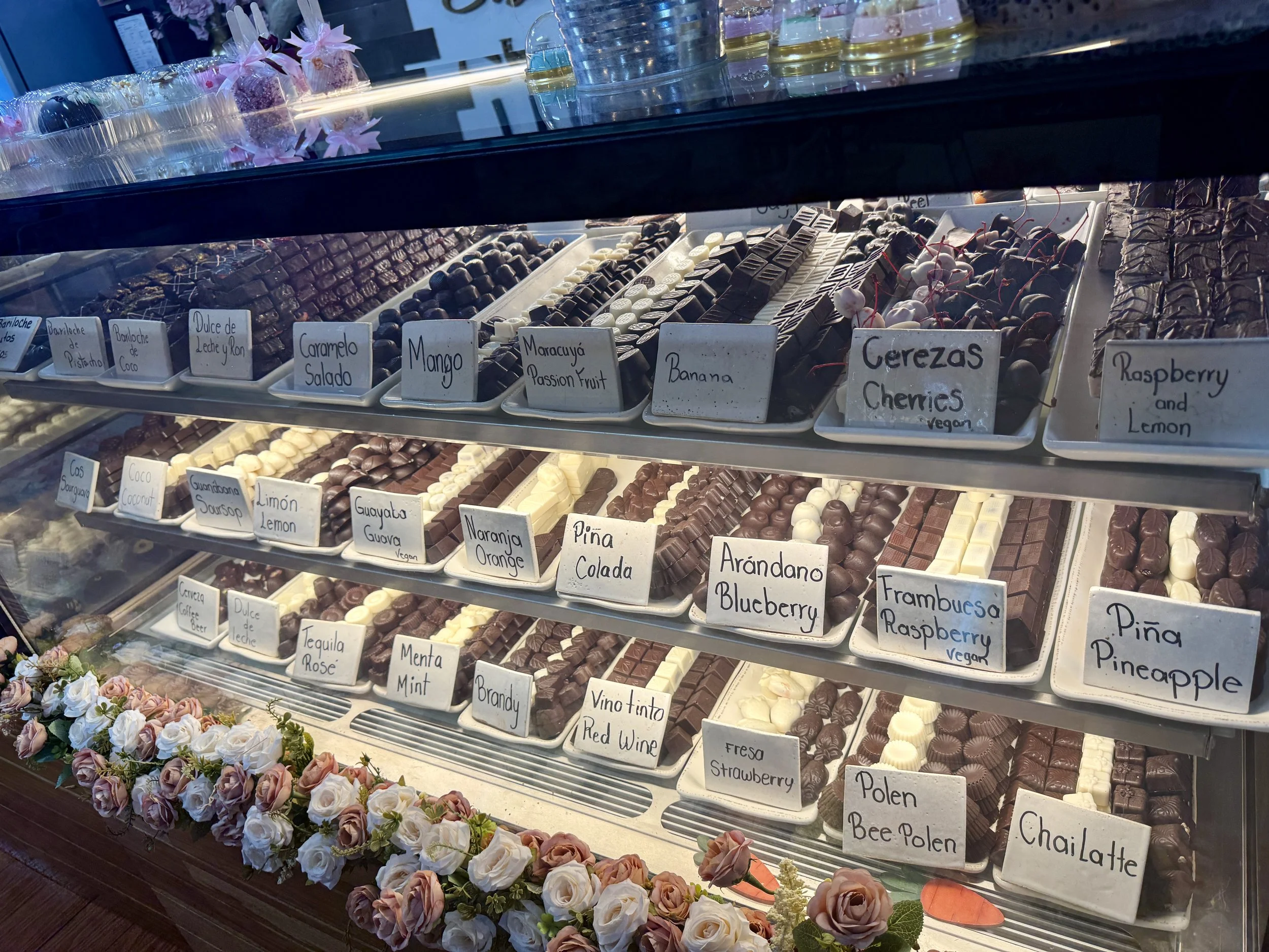 Close-up of chocolate display shelves with labeled varieties arranged in neat rows.