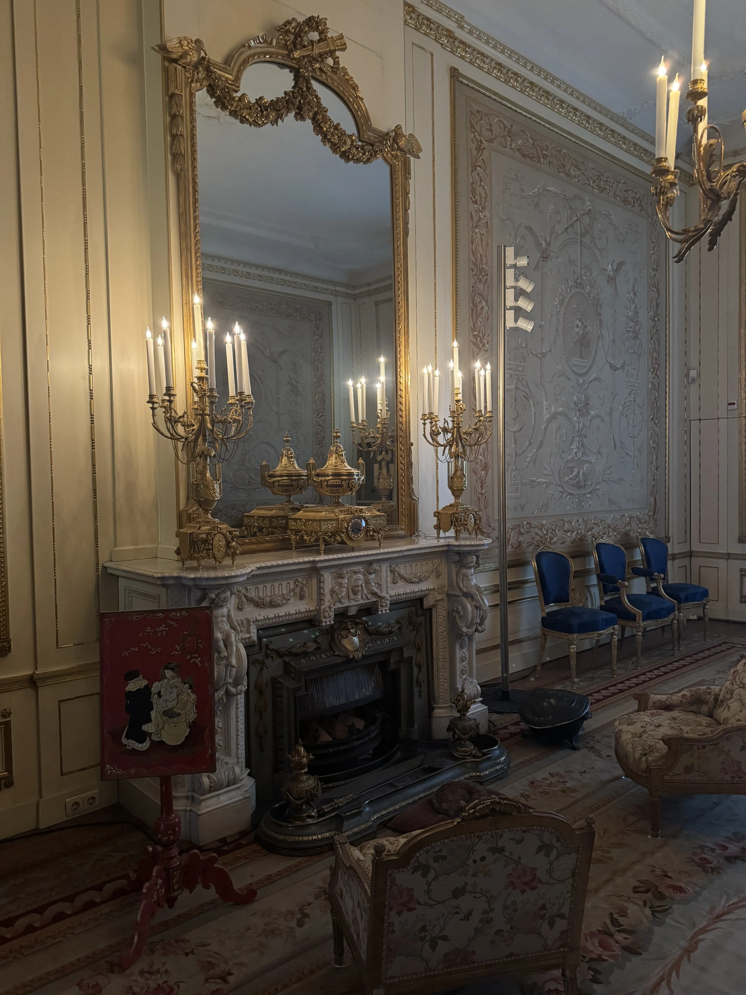 Elegant period sitting room with fireplace, mirror, and chandeliers at Huis Willet-Holthuysen Amsterdam