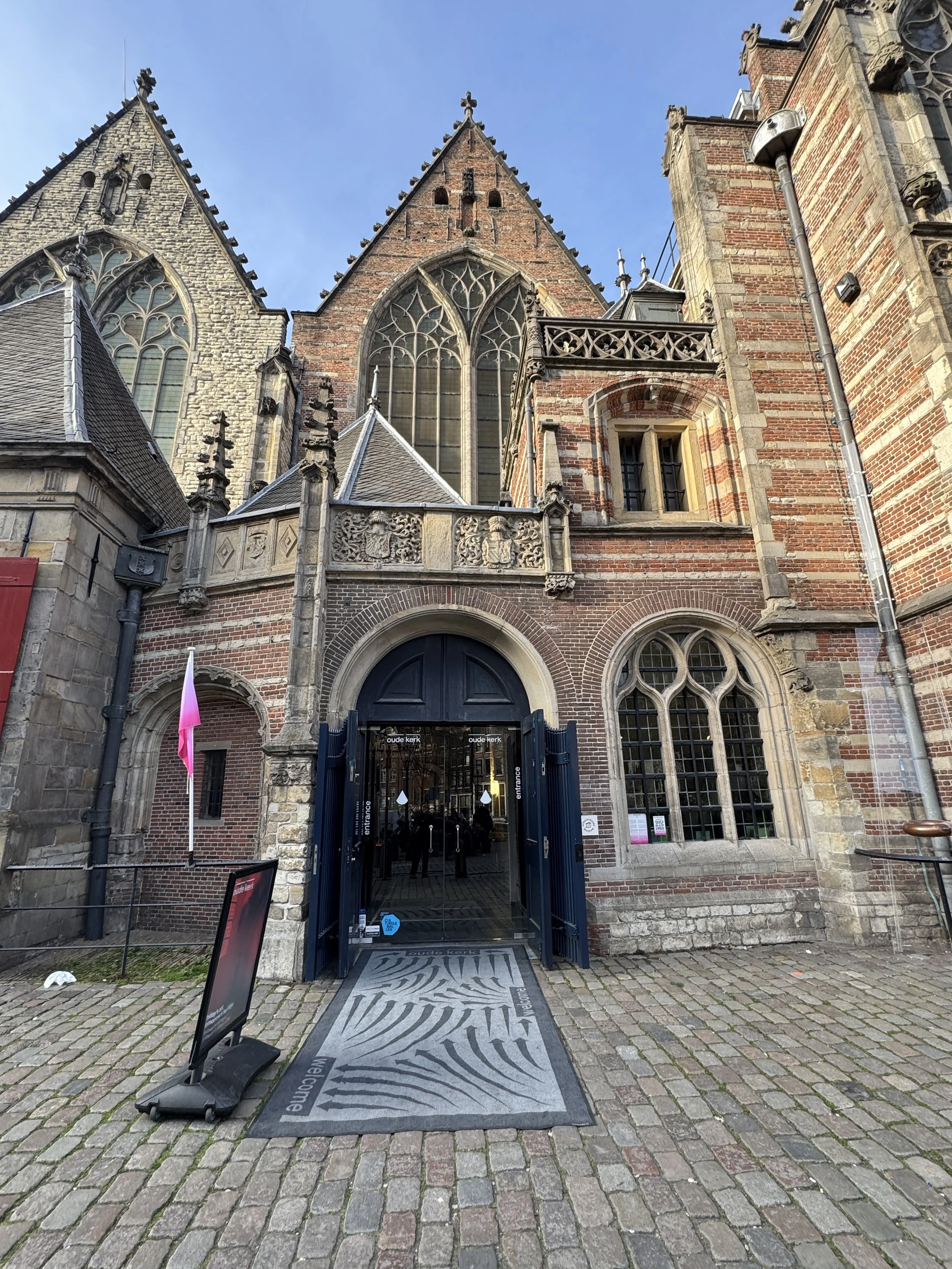 Entrance to Oude Kerk in Amsterdam with historic Gothic architecture and arched doorway