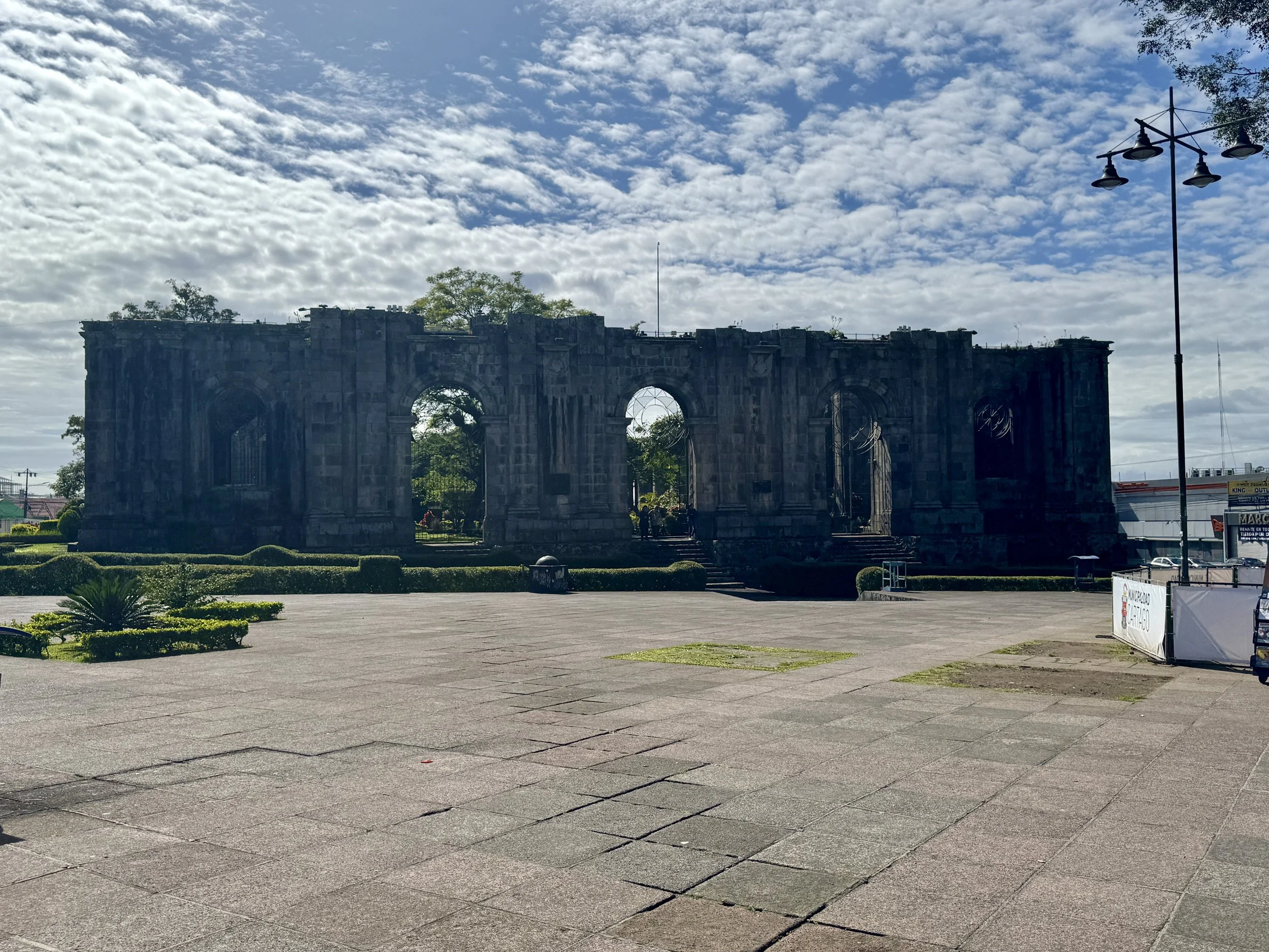 Wide view of the Santiago Apóstol church ruins in Cartago with open plaza in front and mountains in the distance