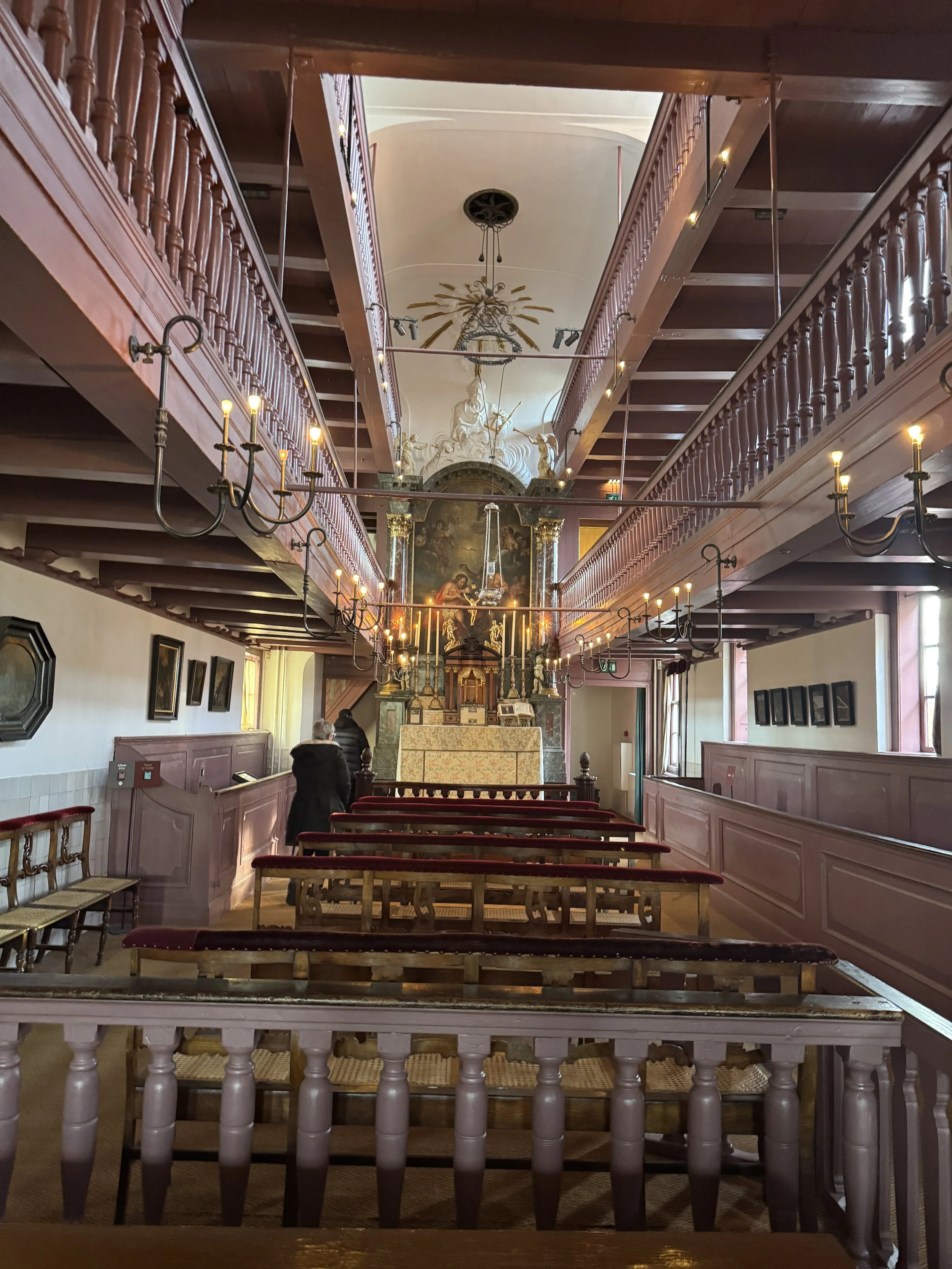Hidden attic church interior at Museum Ons’ Lieve Heer op Solder in Amsterdam with wooden pews and balcony levels