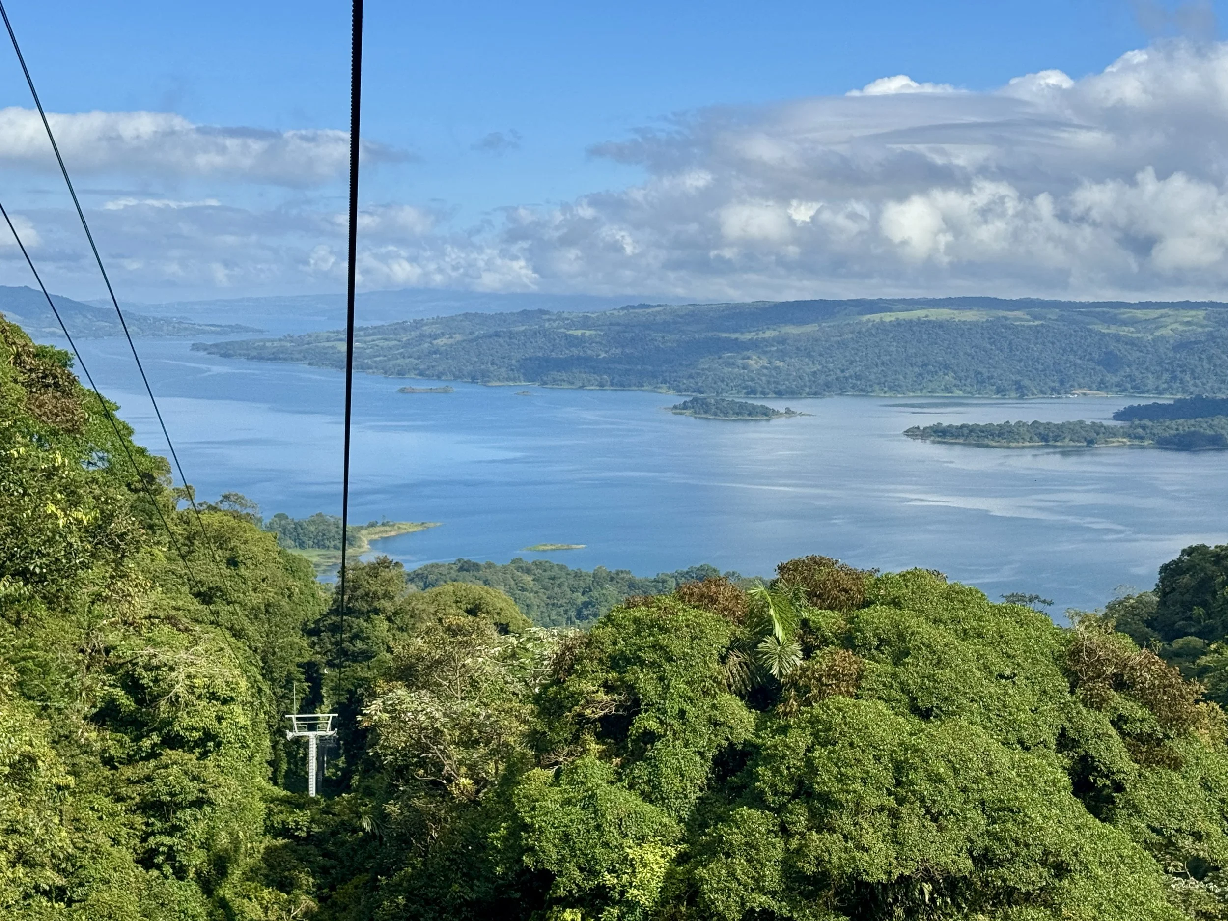 Panoramic view of Lake Arenal from the Sky Adventures tram line above the forest canopy.
