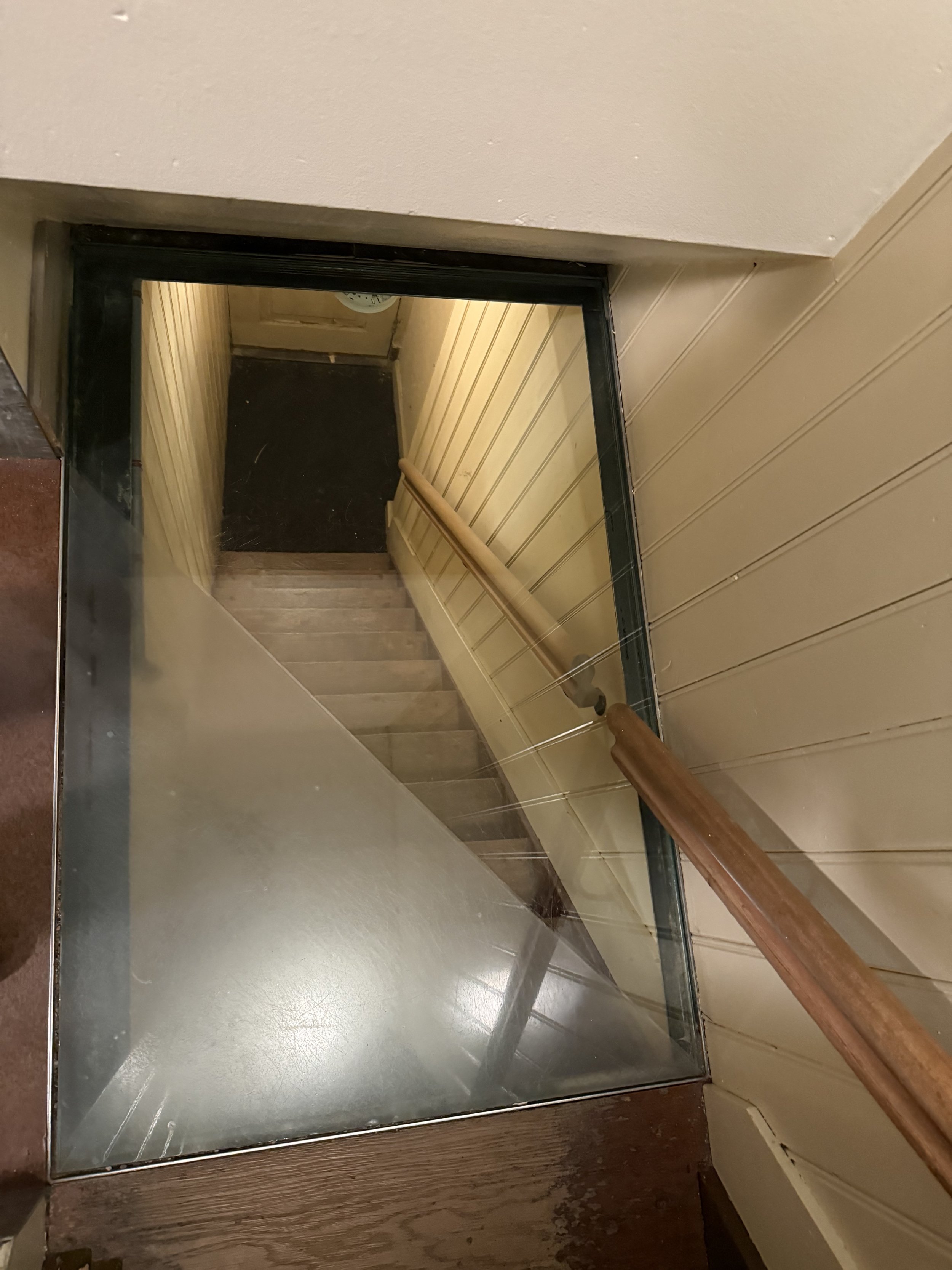 View down a tight stairwell inside the Anne Frank House showing confined interior spaces