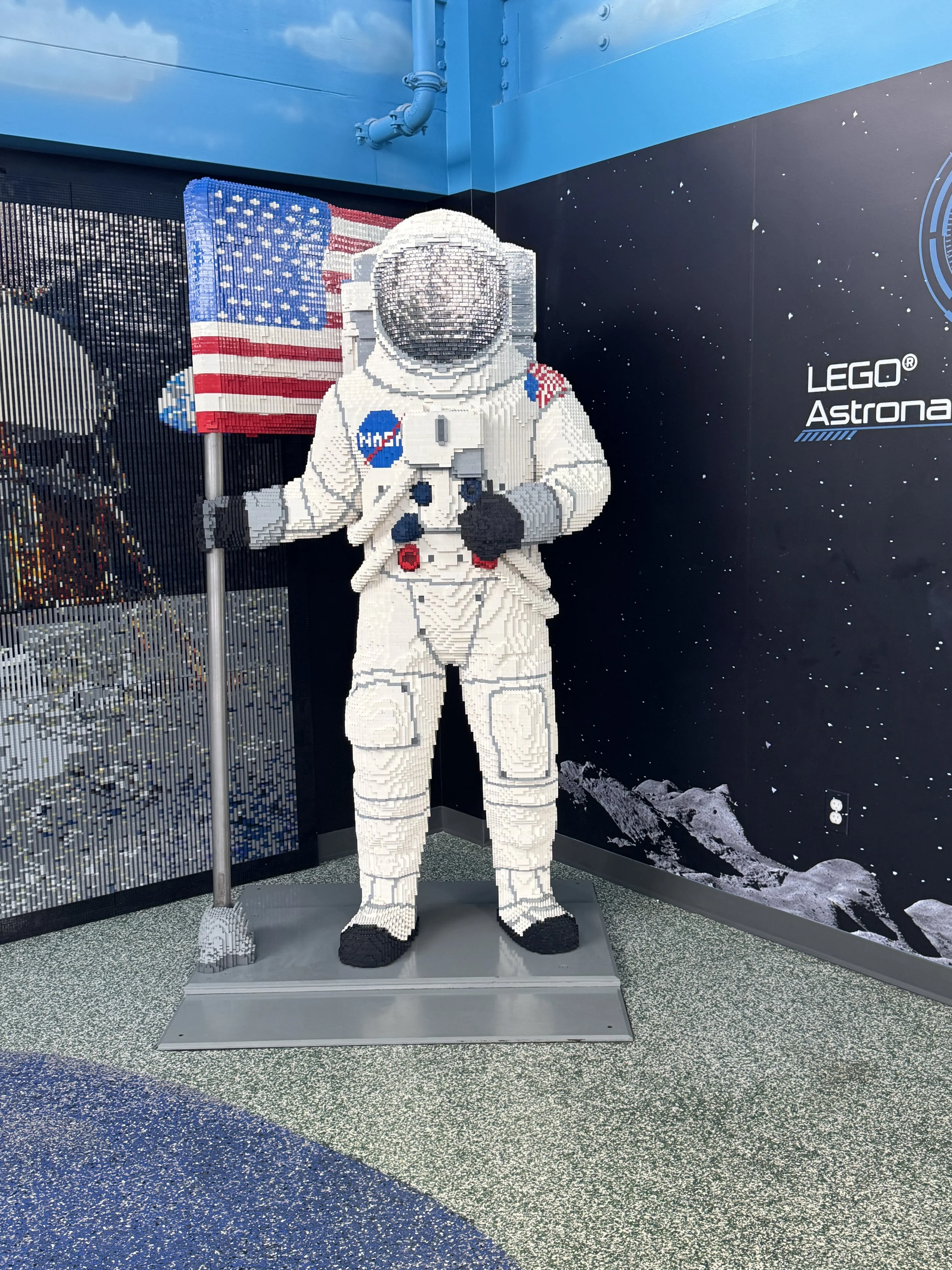 Large LEGO astronaut statue holding an American flag inside LEGOLAND Florida.