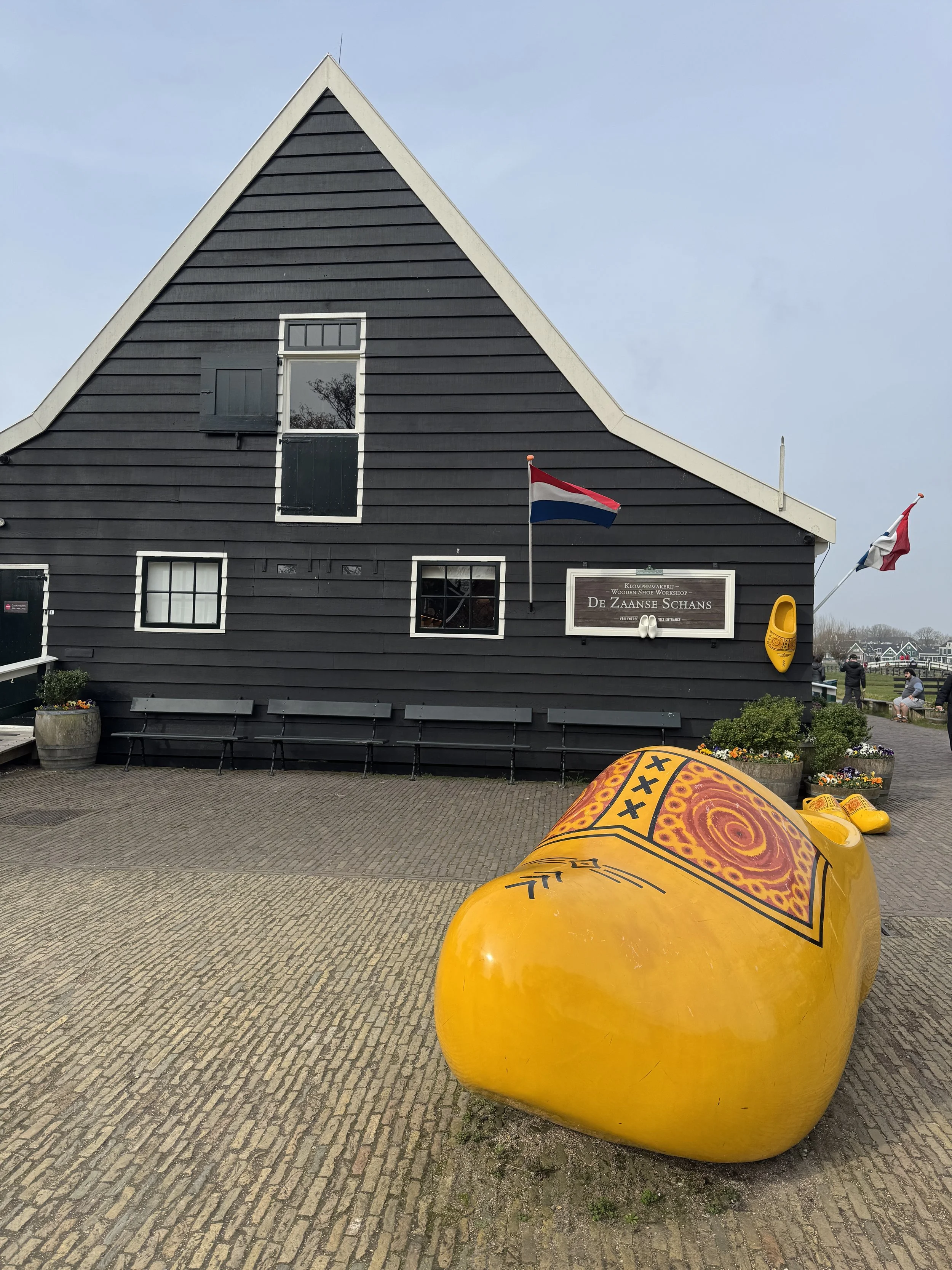 Oversized yellow wooden clogs displayed outside a building at Zaanse Schans