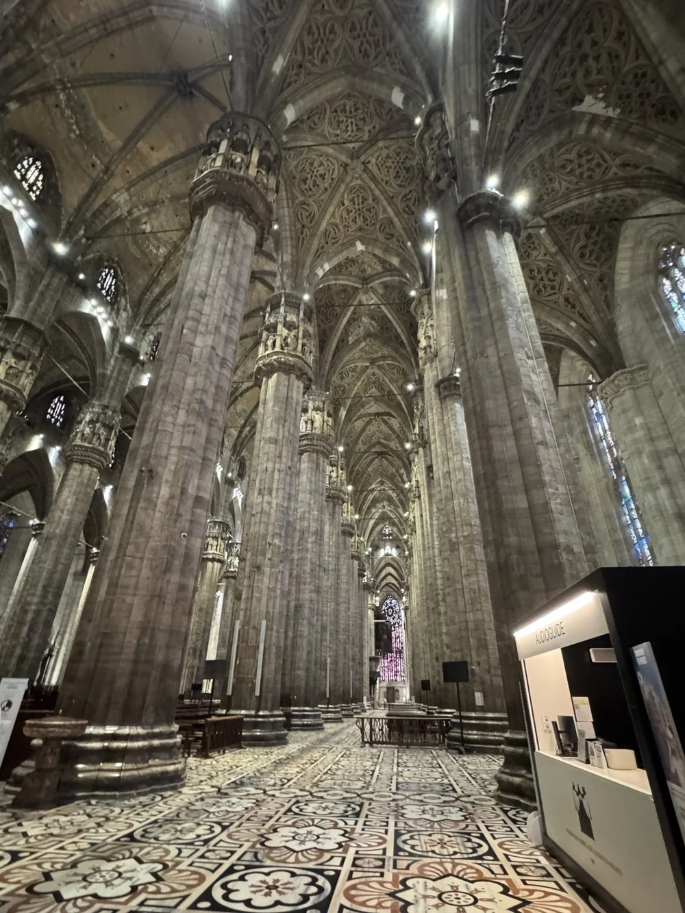 Soaring Gothic columns and patterned marble floor inside Milan Cathedral