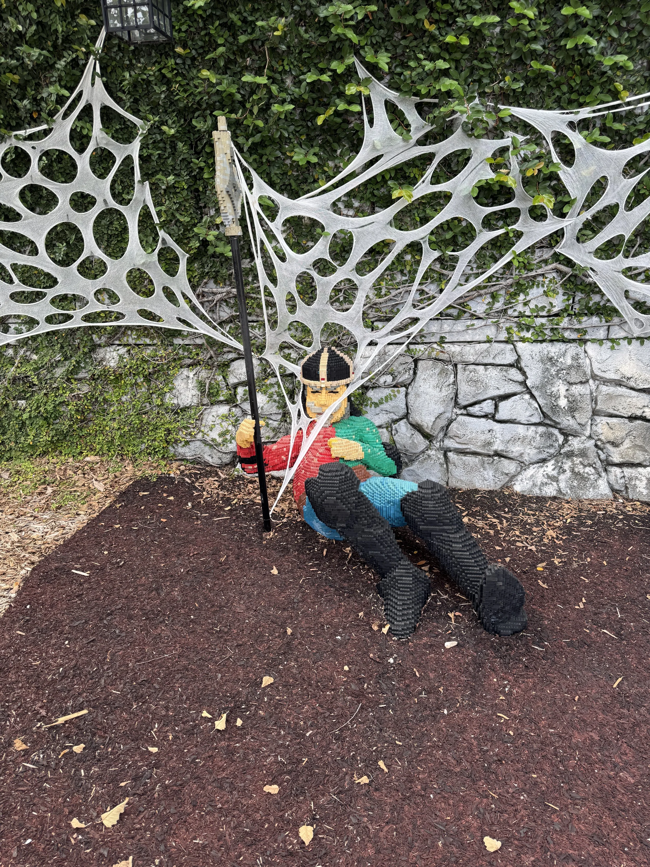 Halloween spider web decoration with a trapped skeleton display at LEGOLAND Florida Resort.