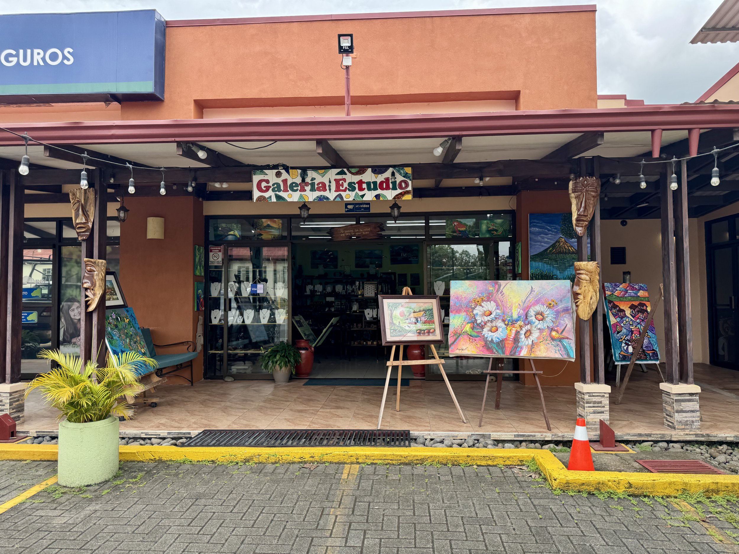 Entrance to Galería Estudio La Fortuna art gallery featuring local artwork on display.