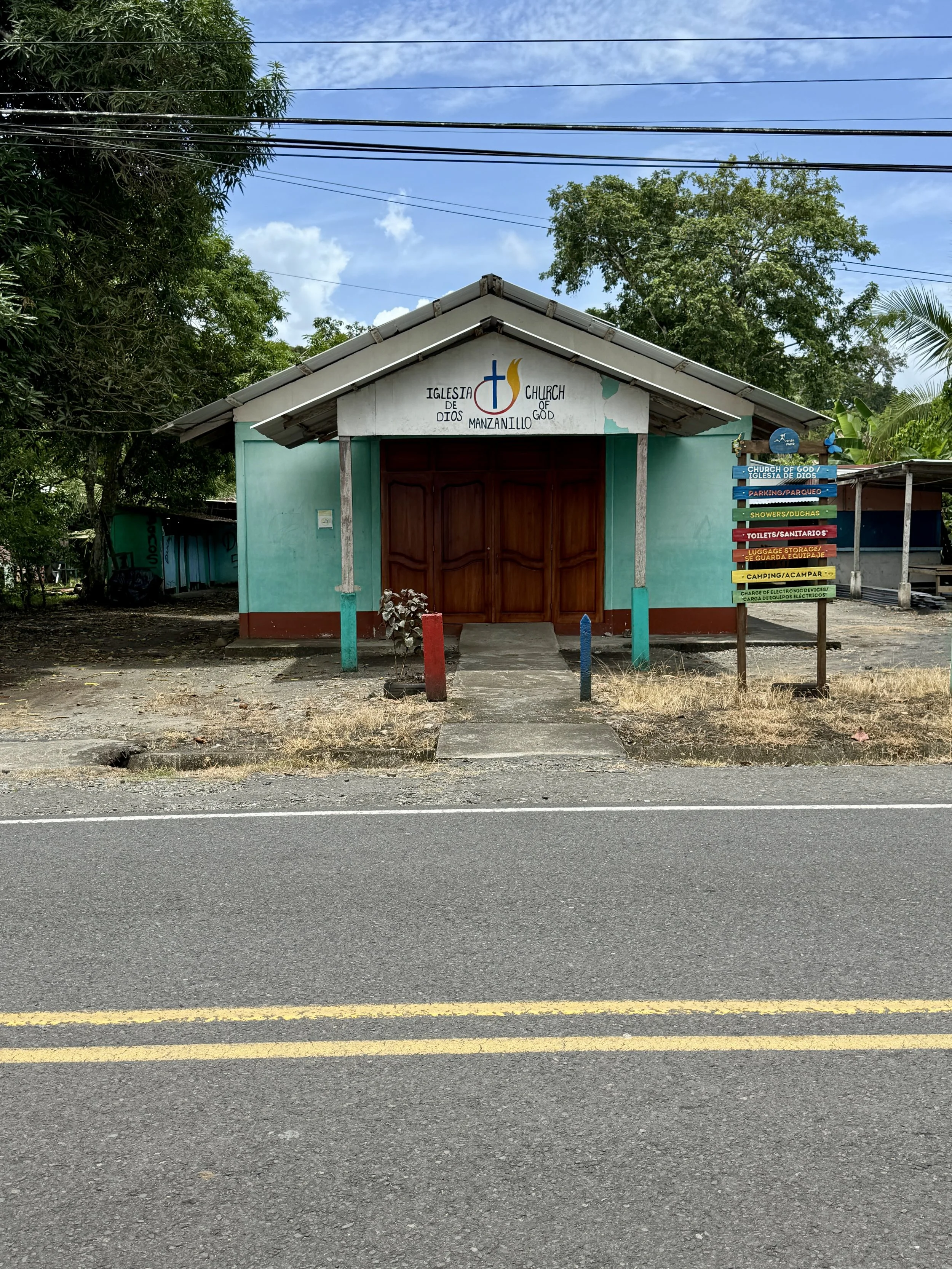 Small colorful wooden building in Manzanillo along the roadside.