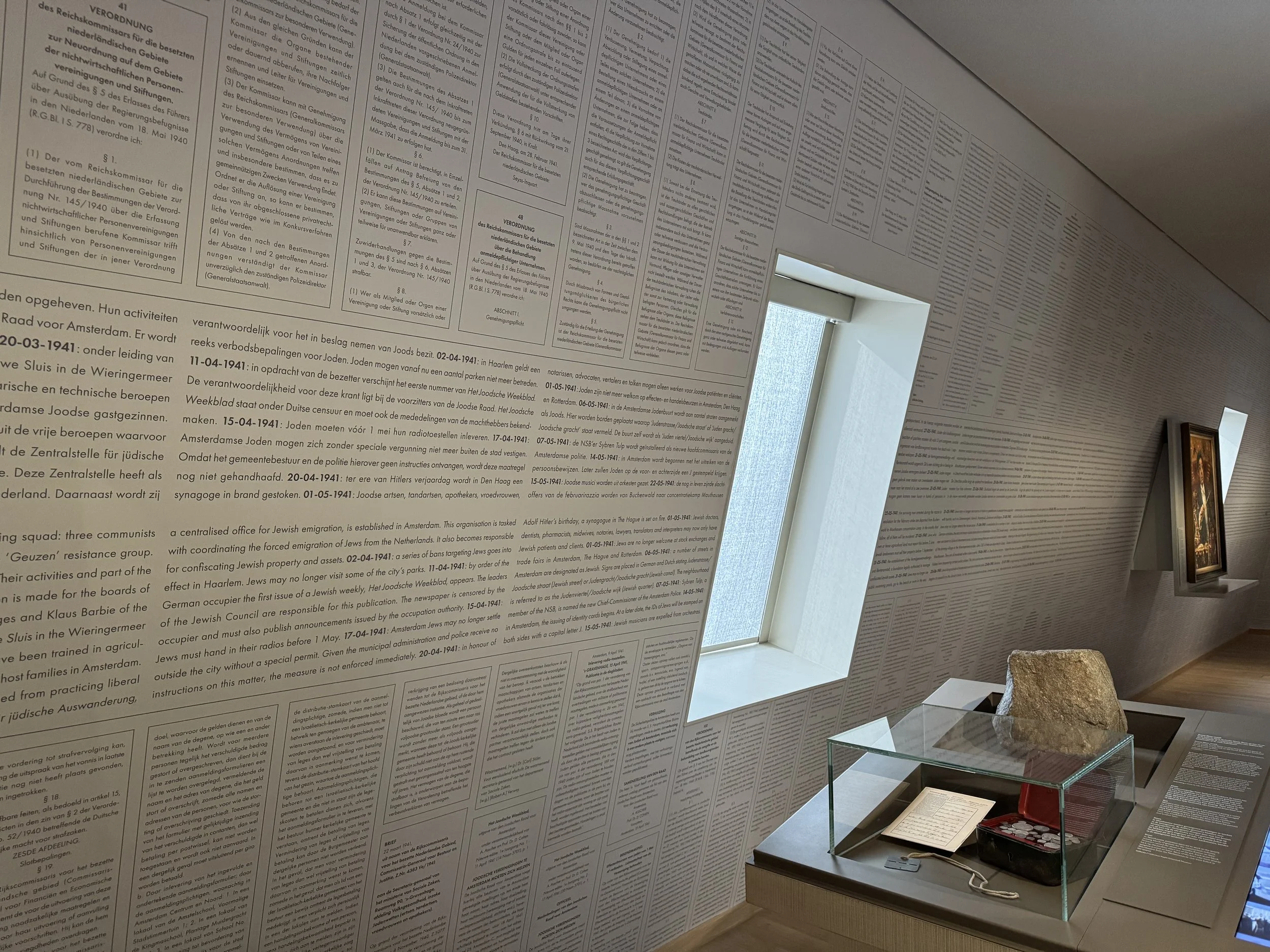 Text-covered memorial wall exhibit inside the National Holocaust Museum in Amsterdam