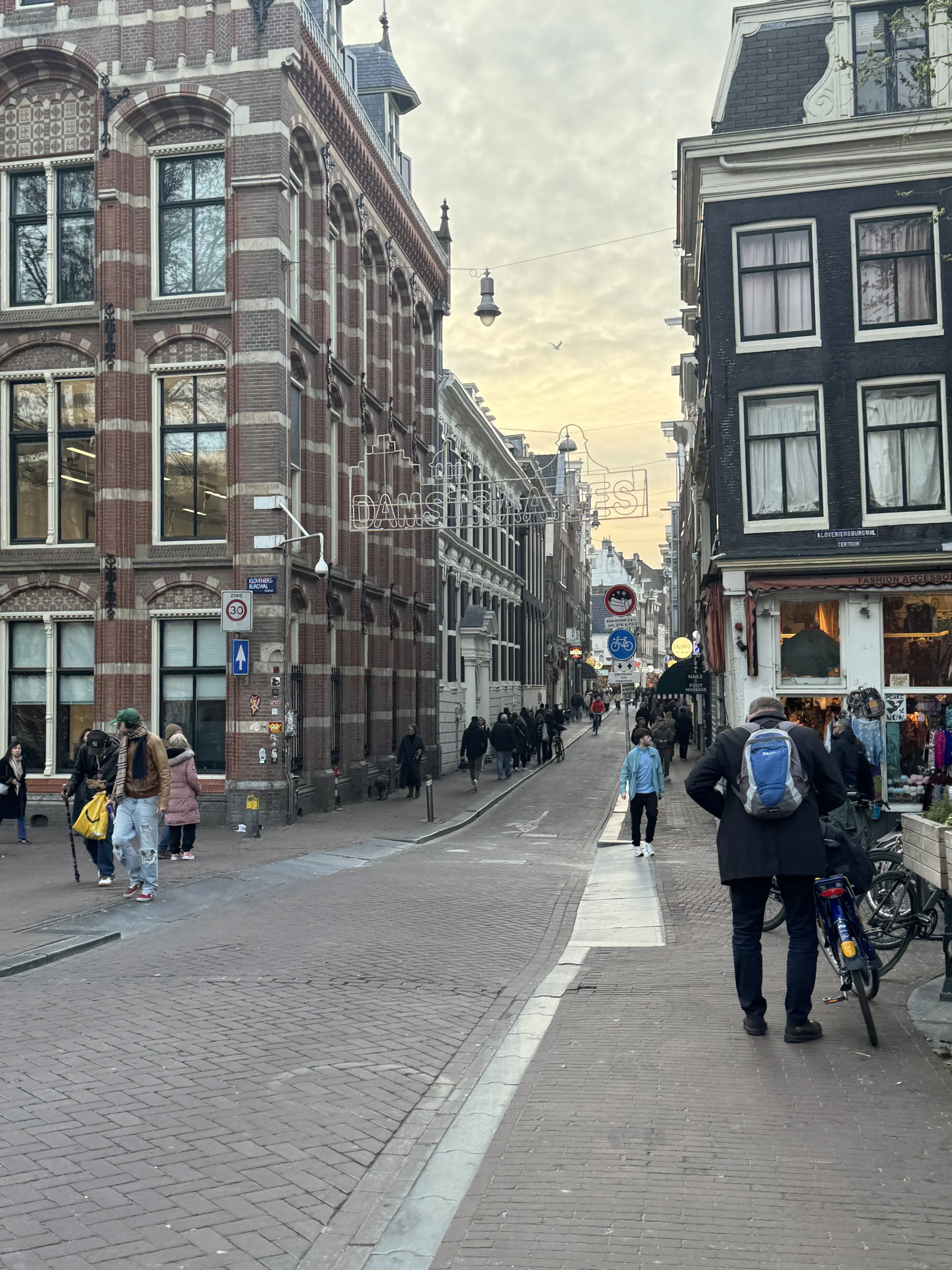 Street view of Damstraatjes in Amsterdam with shops, pedestrians, and historic buildings
