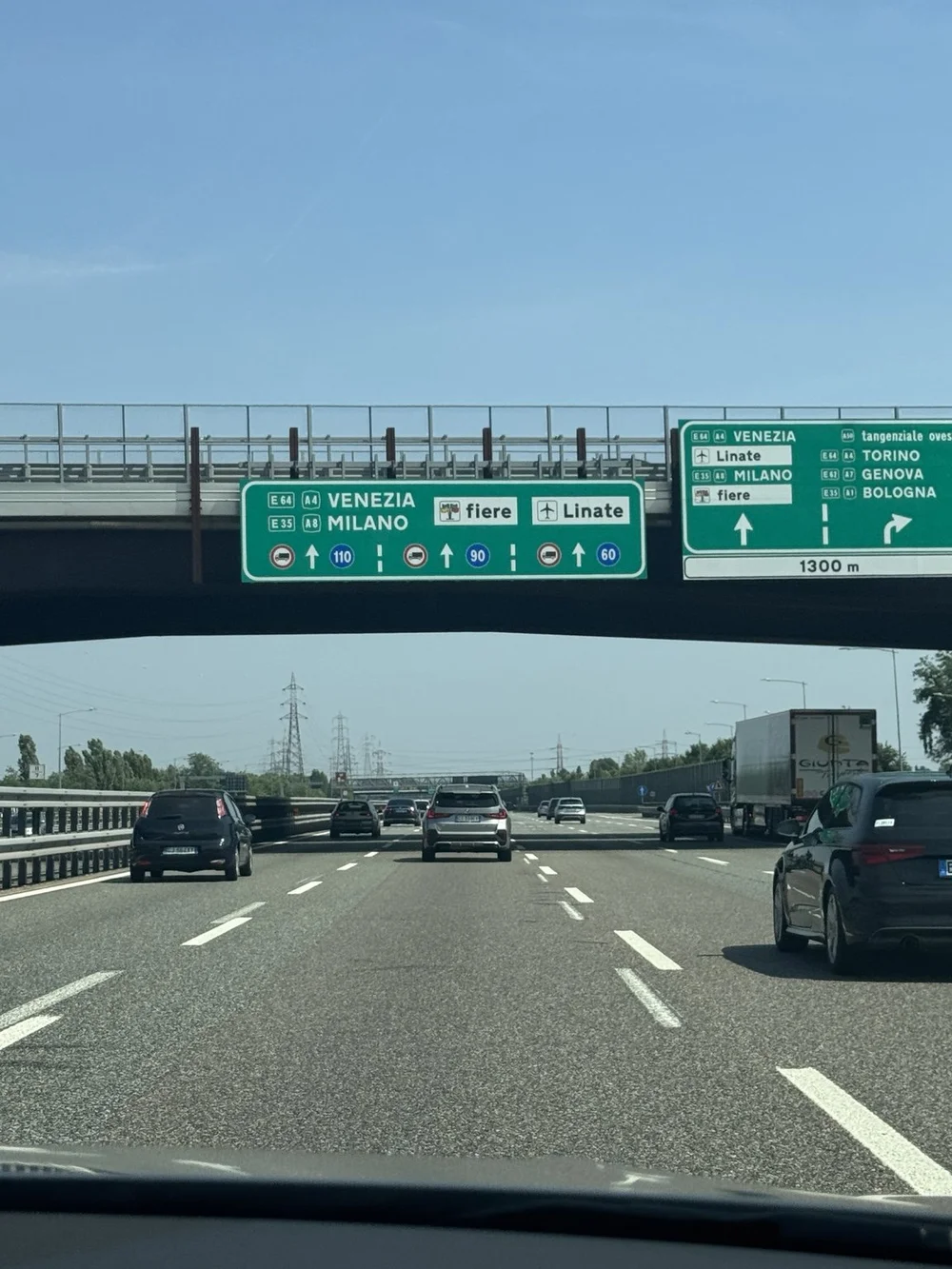 Italian highway signs pointing toward Milan, Venice, Bologna and Linate after arriving in Italy.