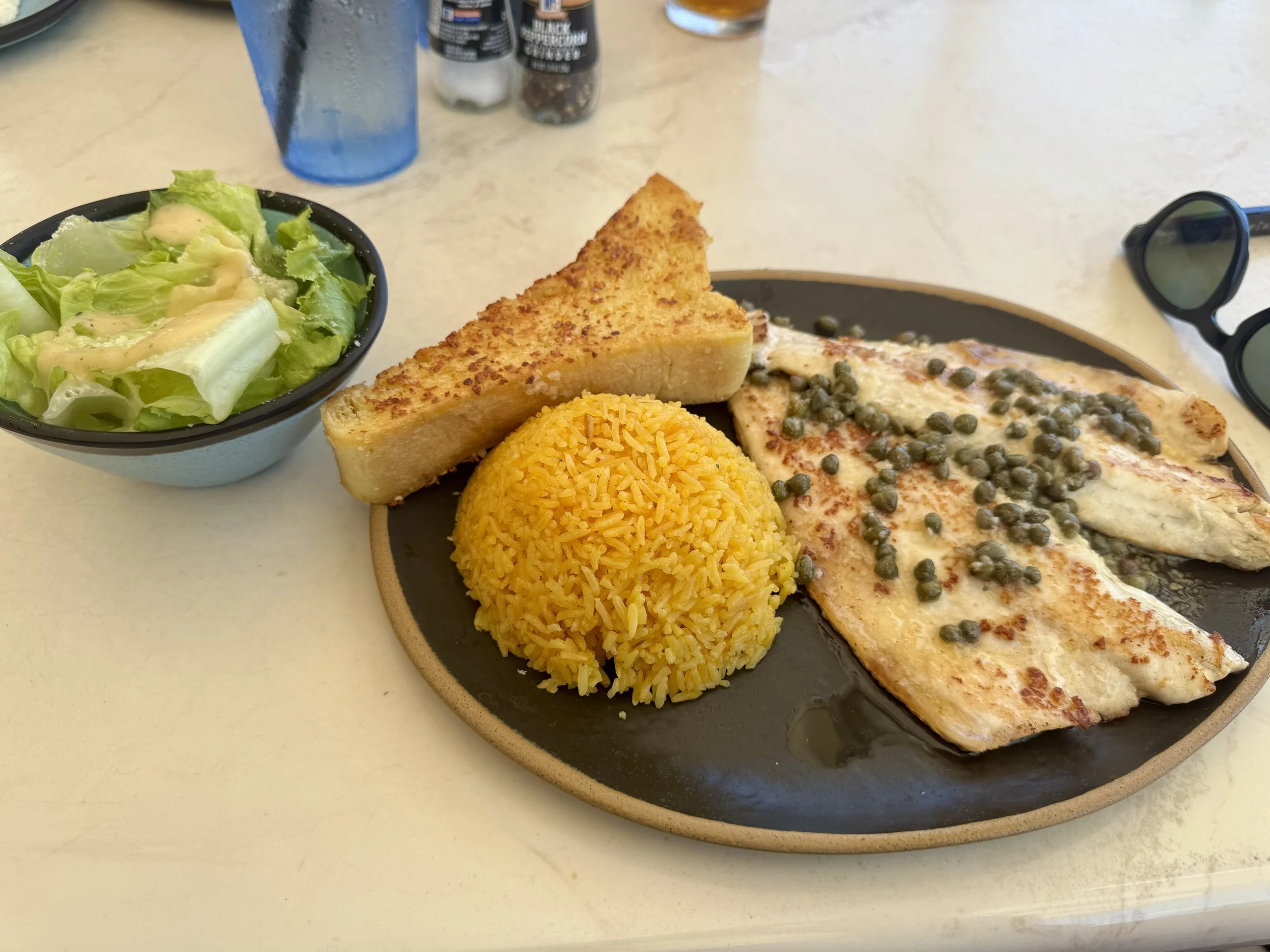 plate with fish yellow rice and salad server at 411 south bar and grill