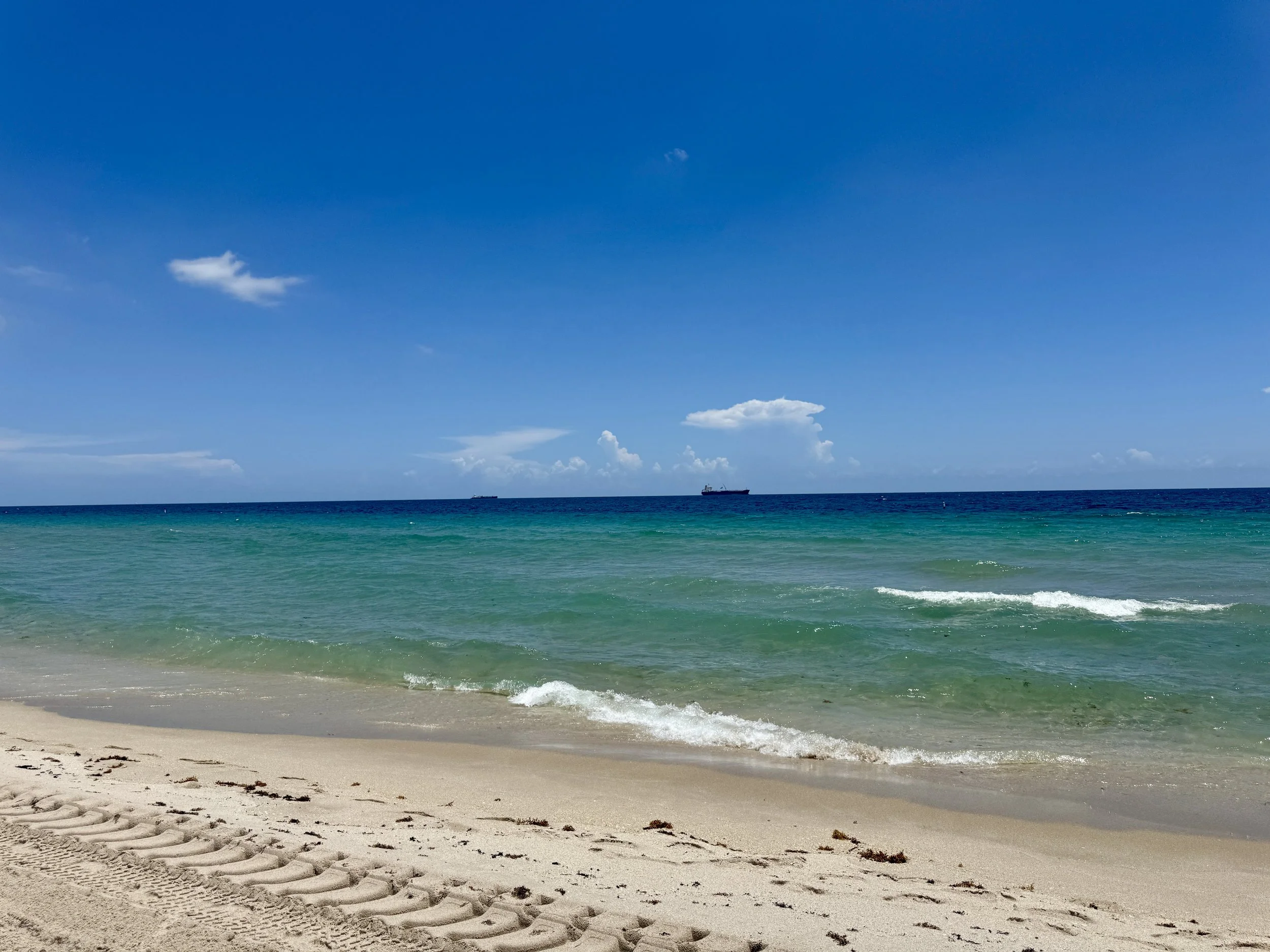 wide view of Fort Lauderdale beach with aquamarine waves and a bright blue sky