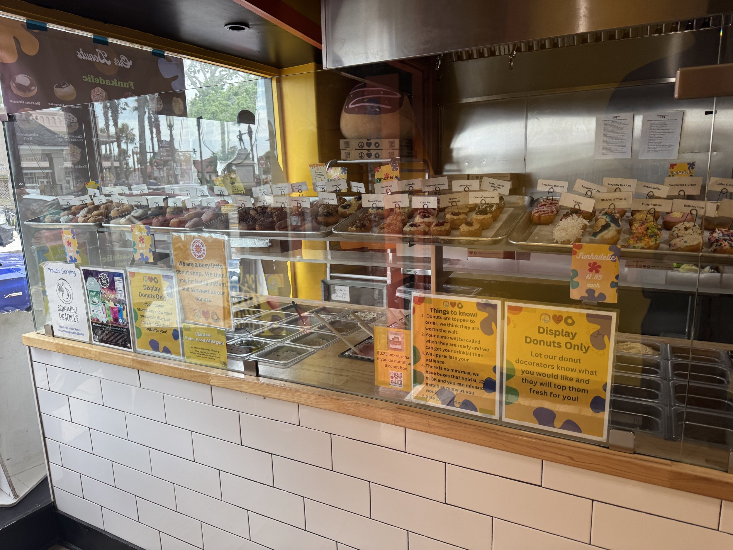 Display case of mini donuts and toppings at Peace, Love and Little Donuts in St. Augustine Florida.