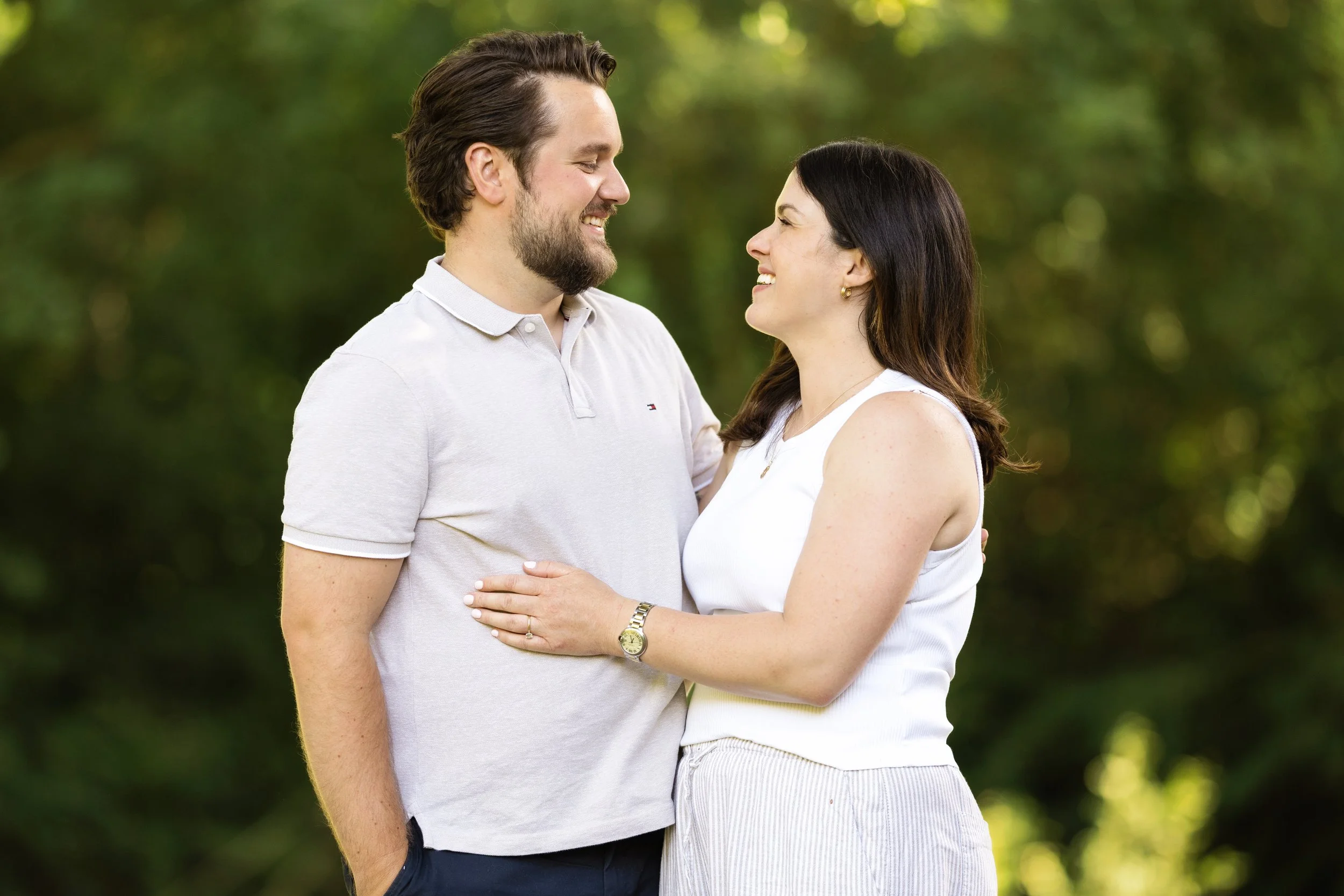 a photo of a couple lovingly staring at each others eyes. both wearing white with the background blurred