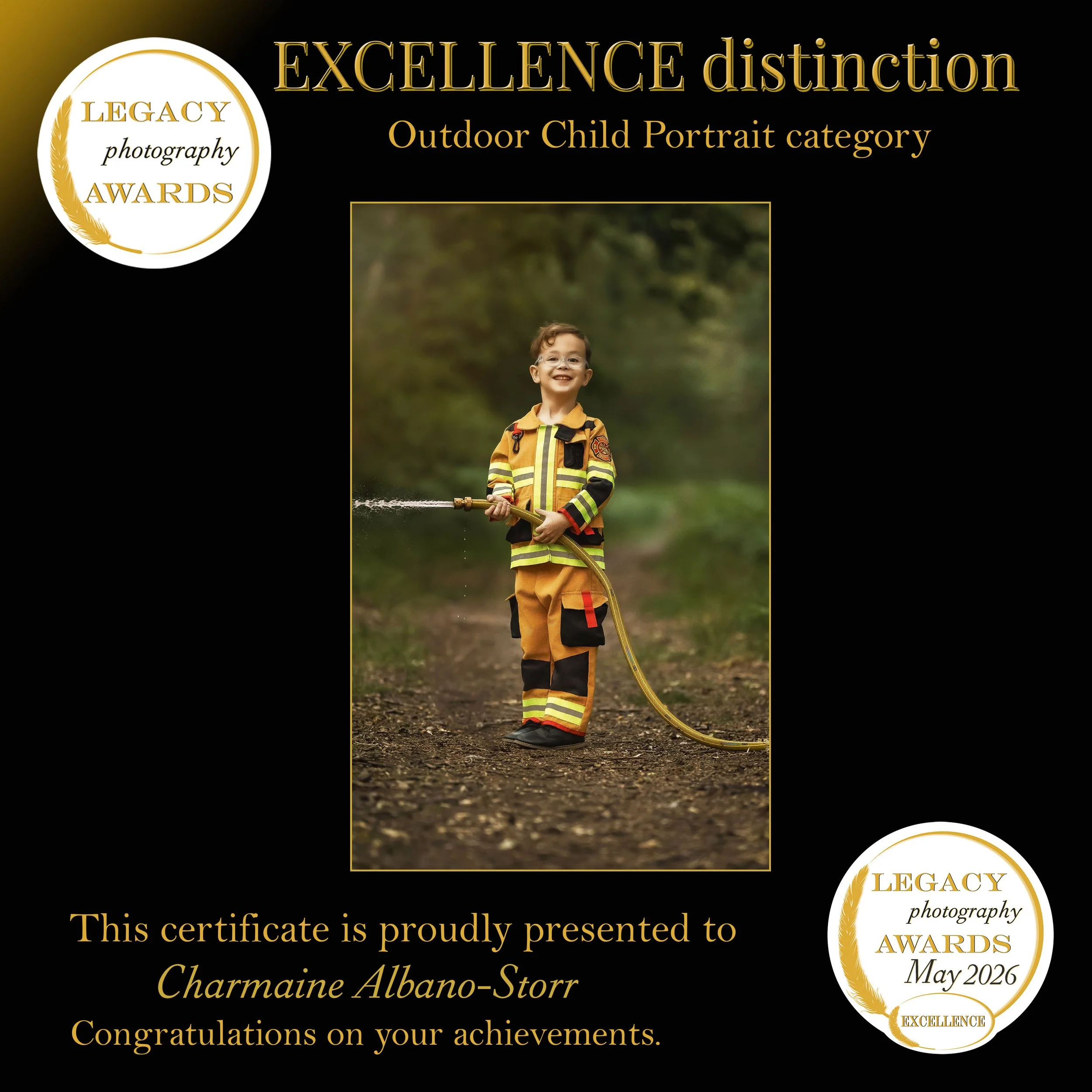 Excellence distinction in the Legacy Photography Awards Outdoor Child Portrait category, featuring a smiling young boy dressed as a firefighter during an outdoor photoshoot.