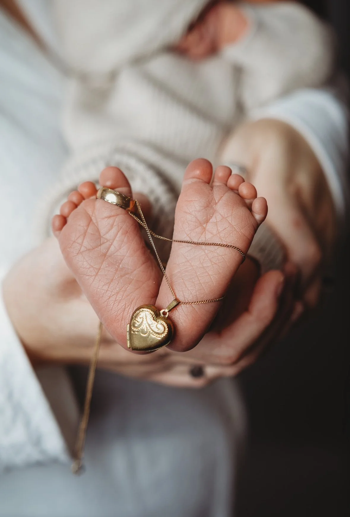 a sentimental hear and ring wrapped around a newborns feet