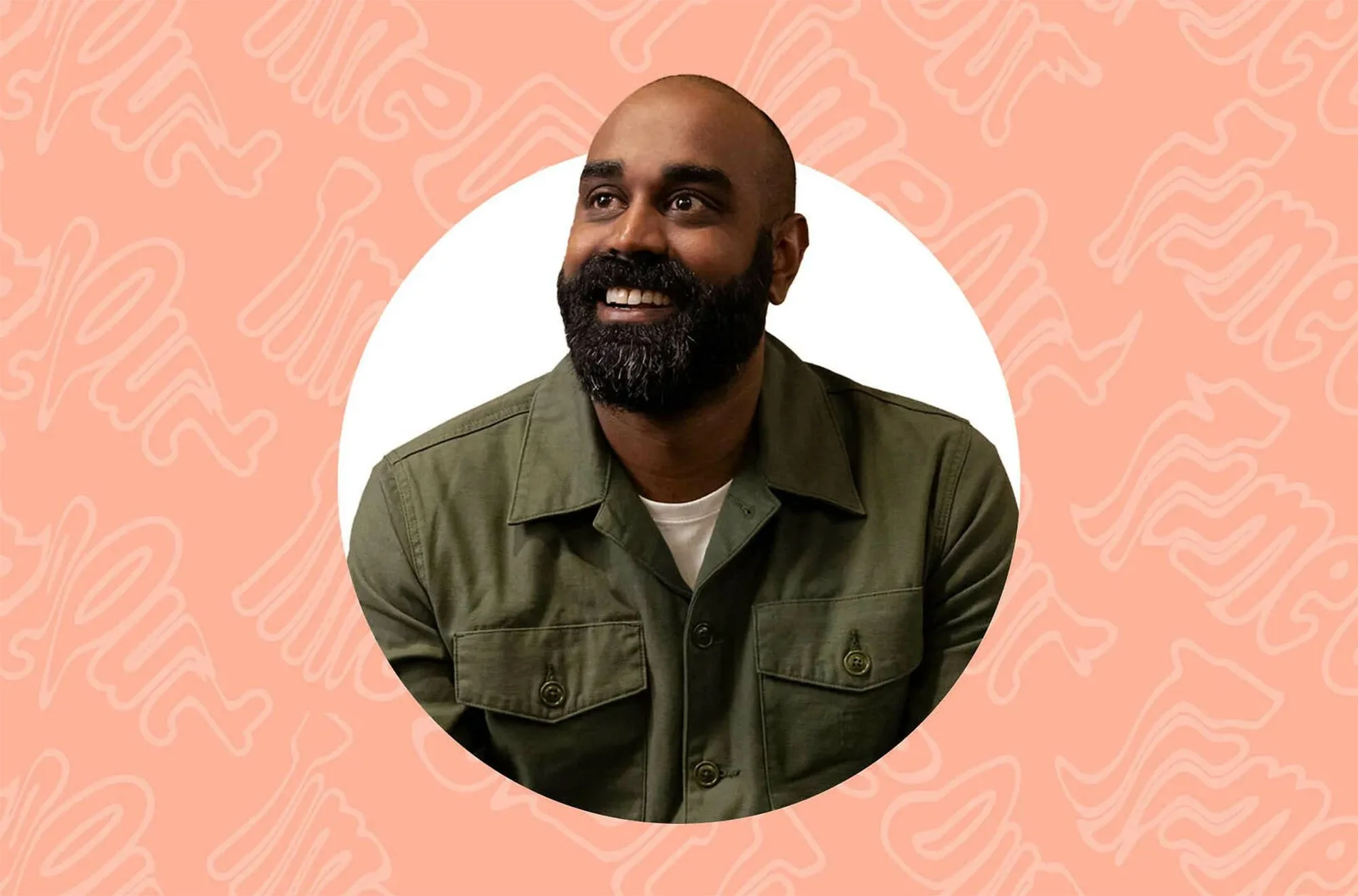 A smiling man with a beard and shaved head, wearing an olive green jacket over a white shirt, sitting against a pink background with light pink abstract wave patterns.