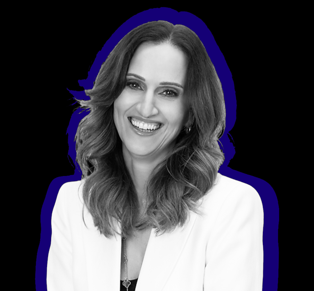 Black-and-white portrait of a smiling woman with wavy hair wearing a white blazer.