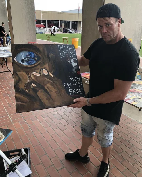 Collector holding the painting How Can We Be Free