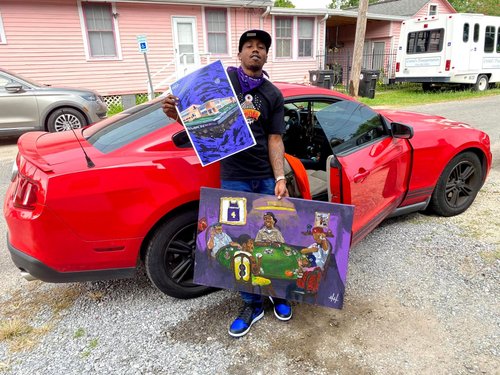 Collector with two paintings beside a red car