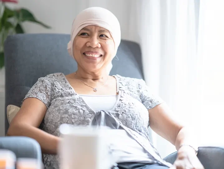 Smiling woman with head covering in a hospital room