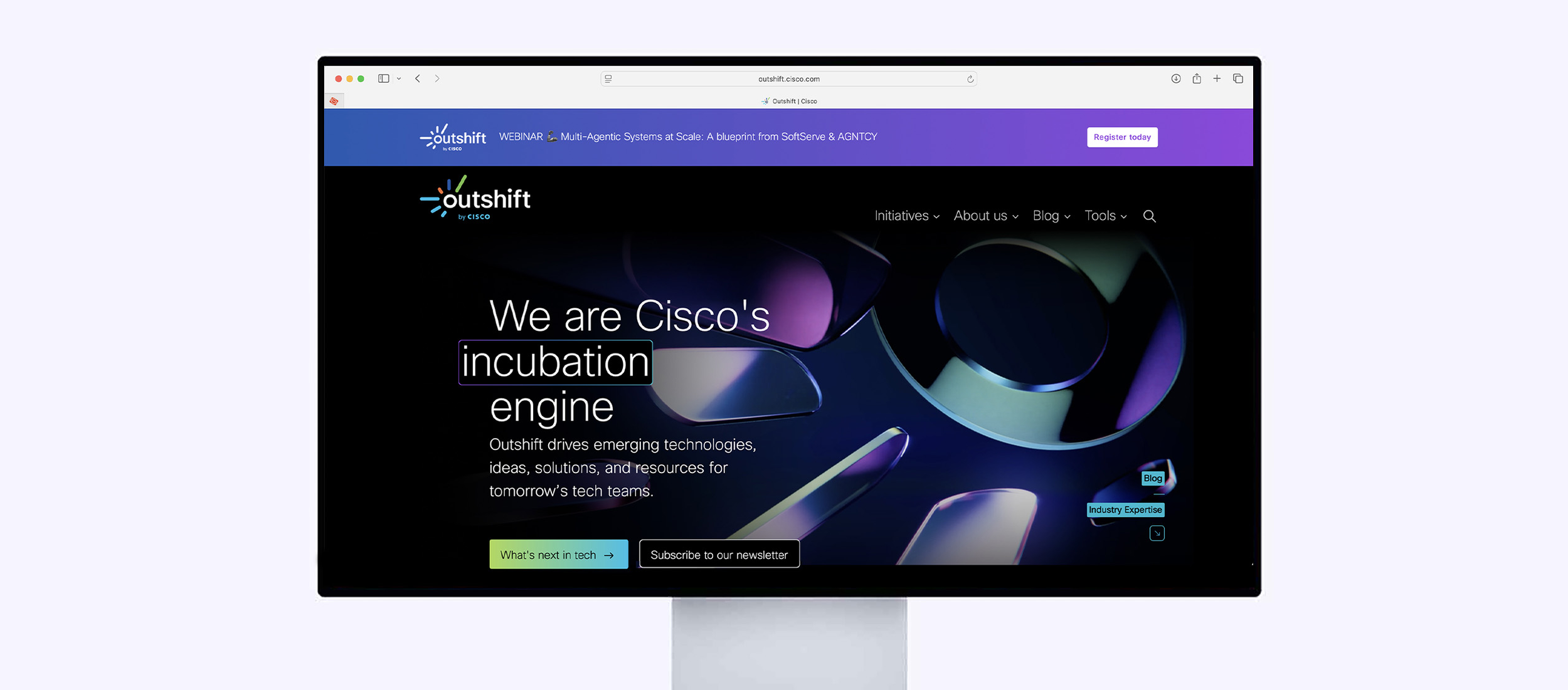 A computer monitor displaying the Outshift website by Cisco, featuring a dark themed homepage with a purple and blue gradient header, logo, navigation menu, and a large headline about Cisco's incubation engine.