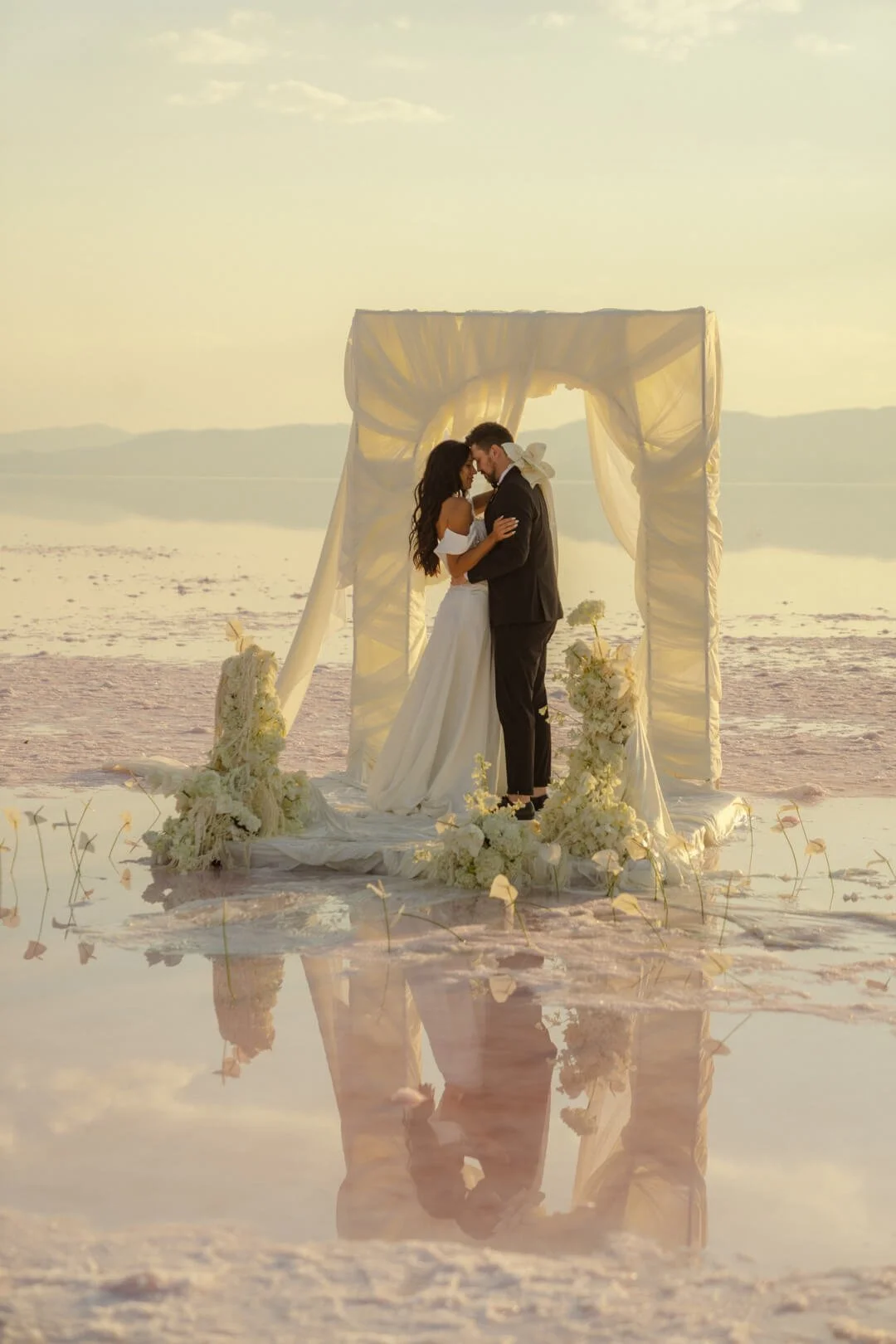 Bride and groom on the Salt Flats, Utah with white ceremony flowers. Designed by Utah florist, Sprigs of Love.