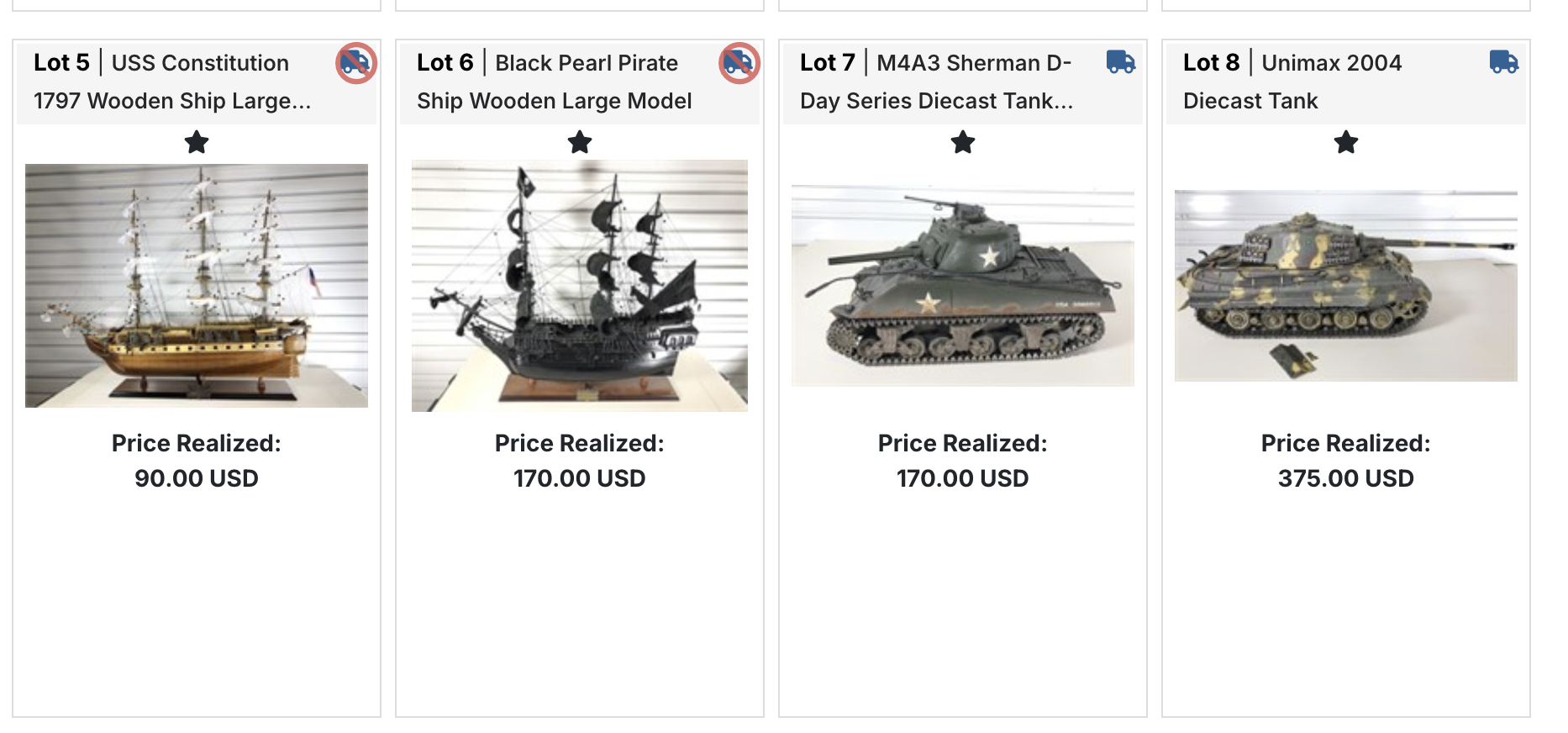 Four model ships and tanks on display with prices below each for an online auction.
