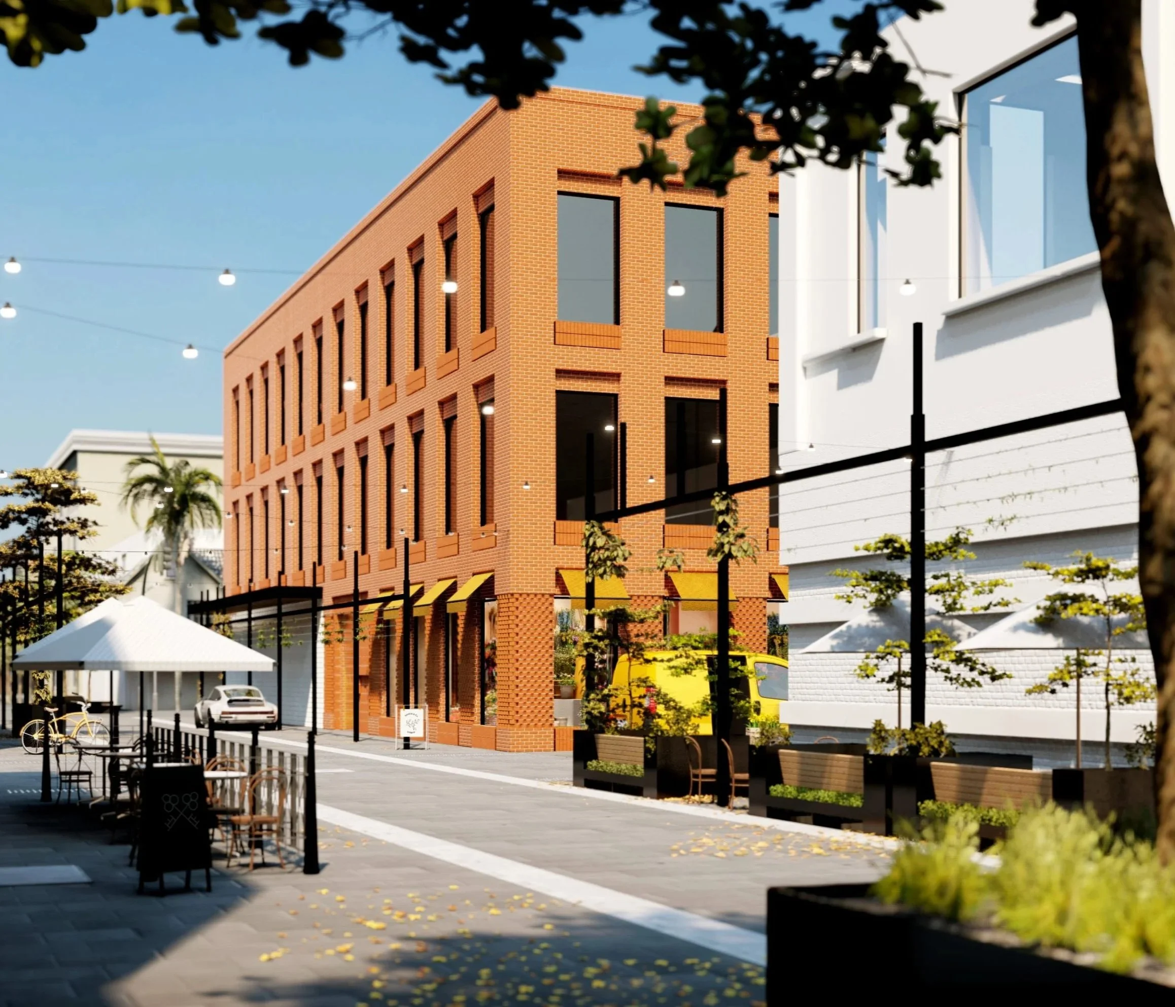 A lively outdoor shopping mall with a large red brick building with tall windows, string lights overhead, trees, benches, and a white building with modern architecture, parked cars, and bicycles in the foreground.