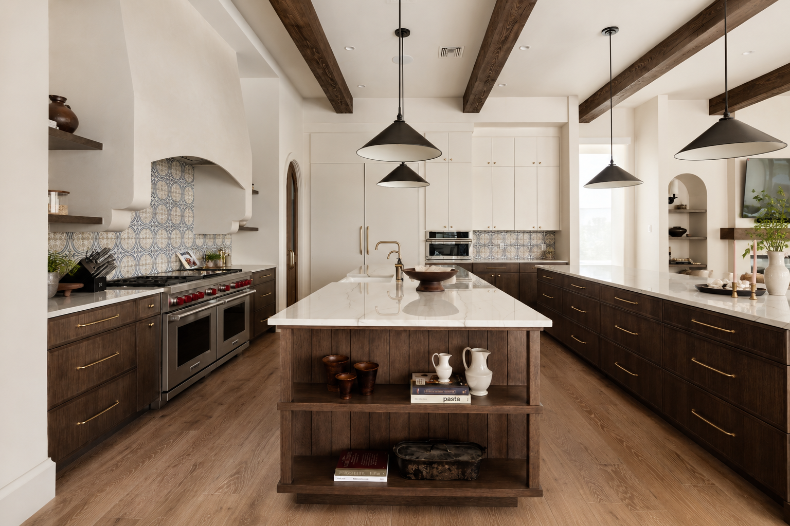 Modern kitchen with a large island, white marble countertop, dark wood cabinetry, pendant lights, patterned backsplash, and hardwood floors.