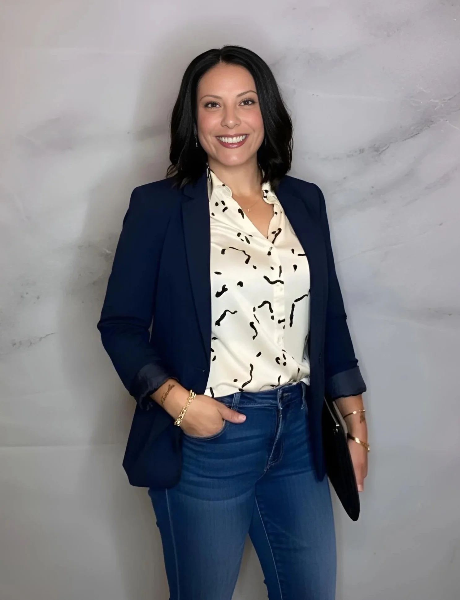 Picture of the founder Brenda Santiago, smiling into the camera holding her iPad which is her home base for her business. Standing in front of her white marble backdrop ready to create an experience