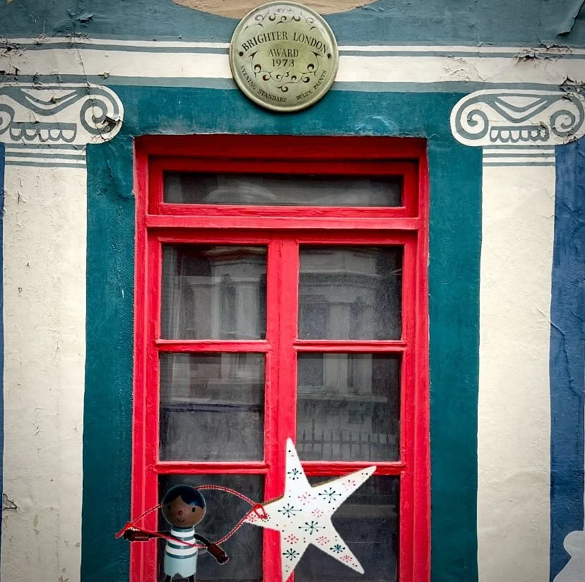 Play is not a luxury. It is a necessity of life to understand, navigate and adapt to the complexities of the world 

IMAGE DESCRIPTION: The image features a red window adorned with a star doll figure holding a star, resembling a child with a kite set