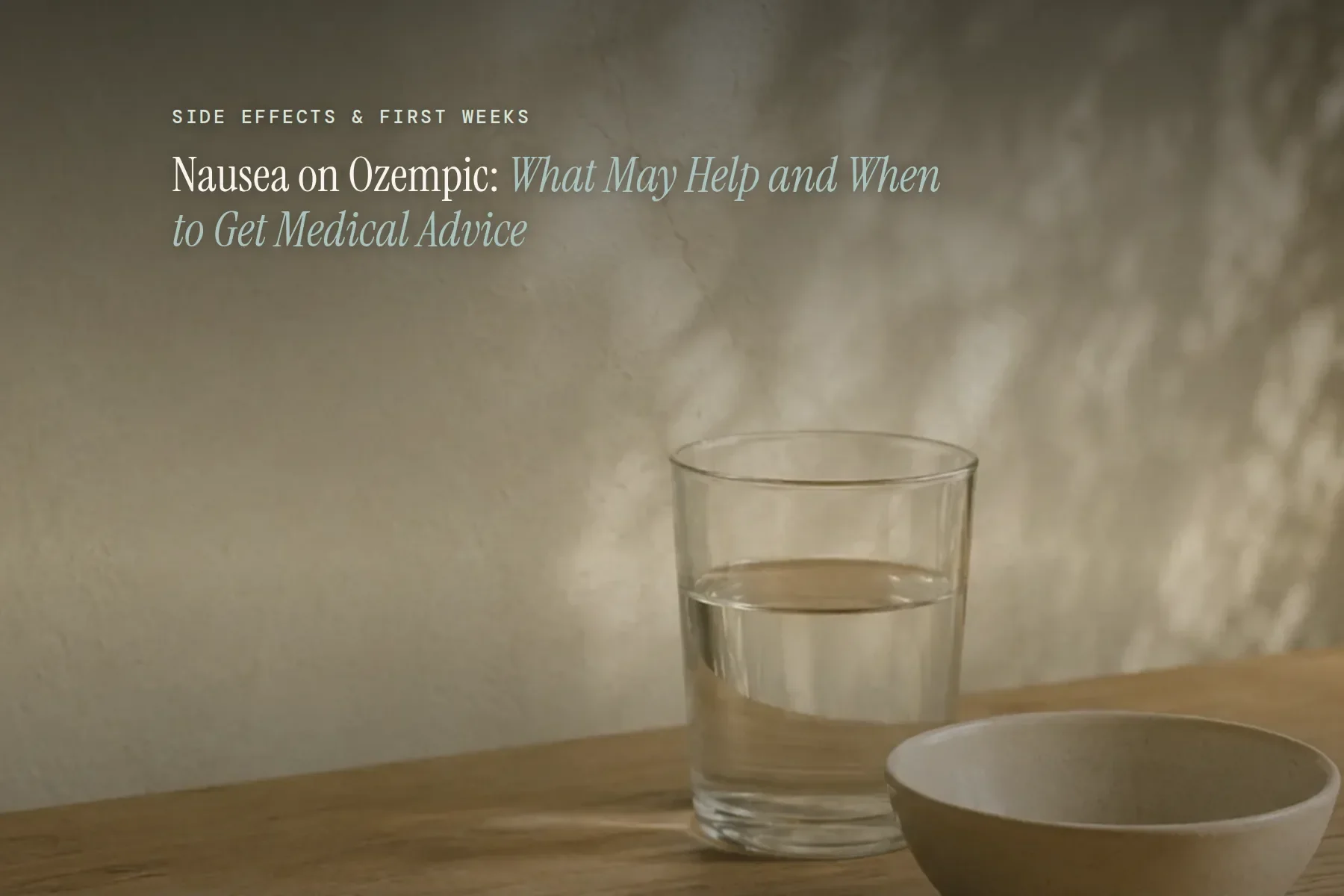 Glass of water and a small ceramic bowl on a sunlit wooden table — "Nausea on Ozempic: What May Help and When to Get Medical Advice."