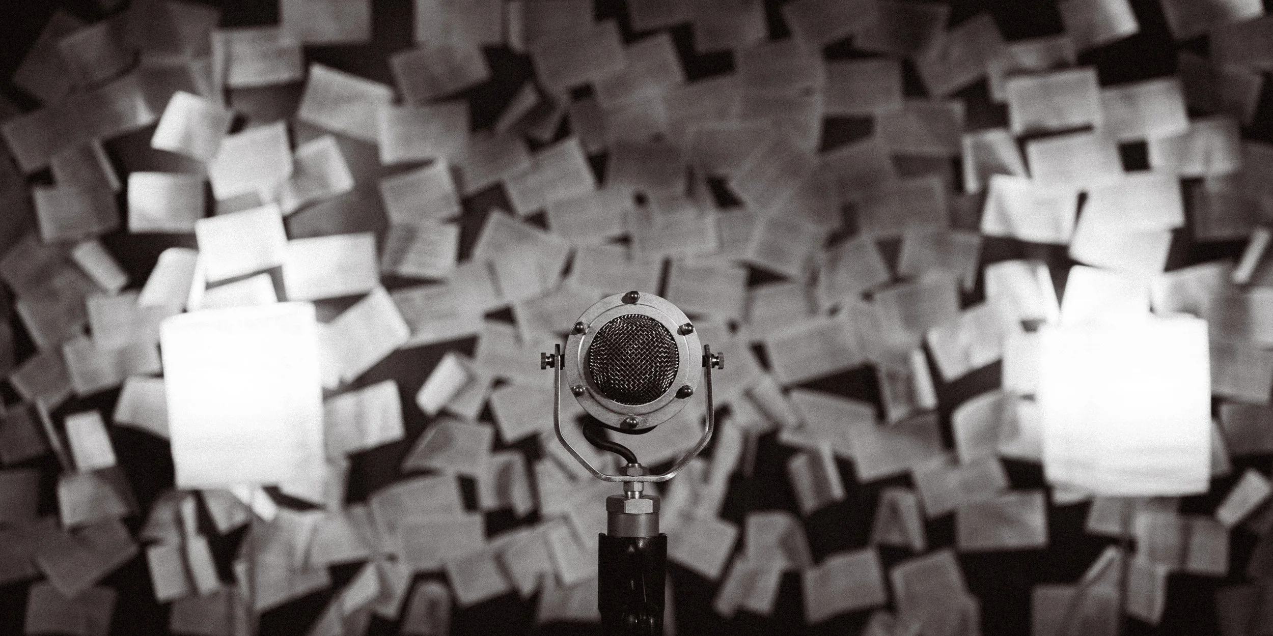 Microphone in recording studio with acoustic foam panels in the background.